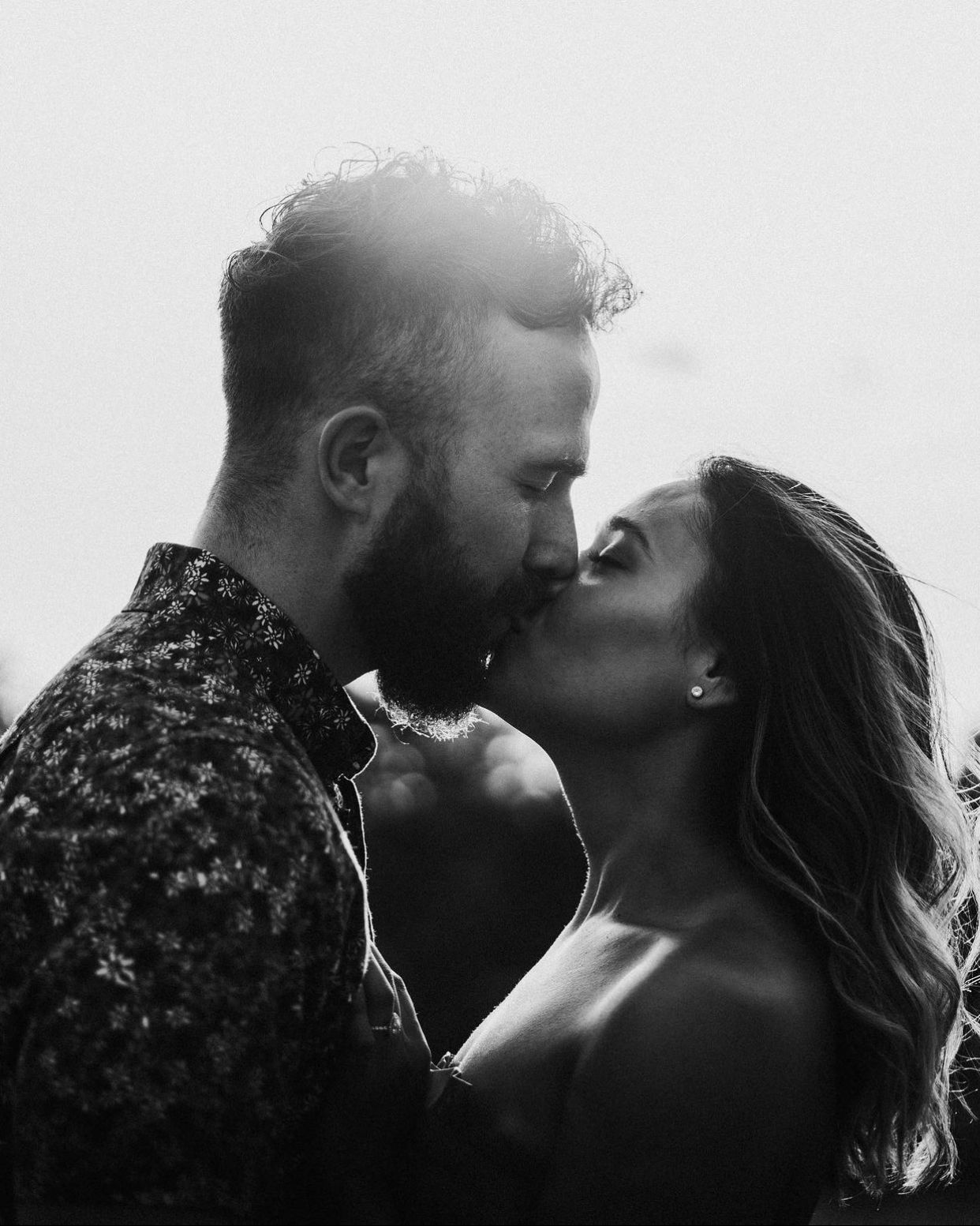 Black and white cinematic portrait of couple sharing a kiss by Bylitos Studio Michigan