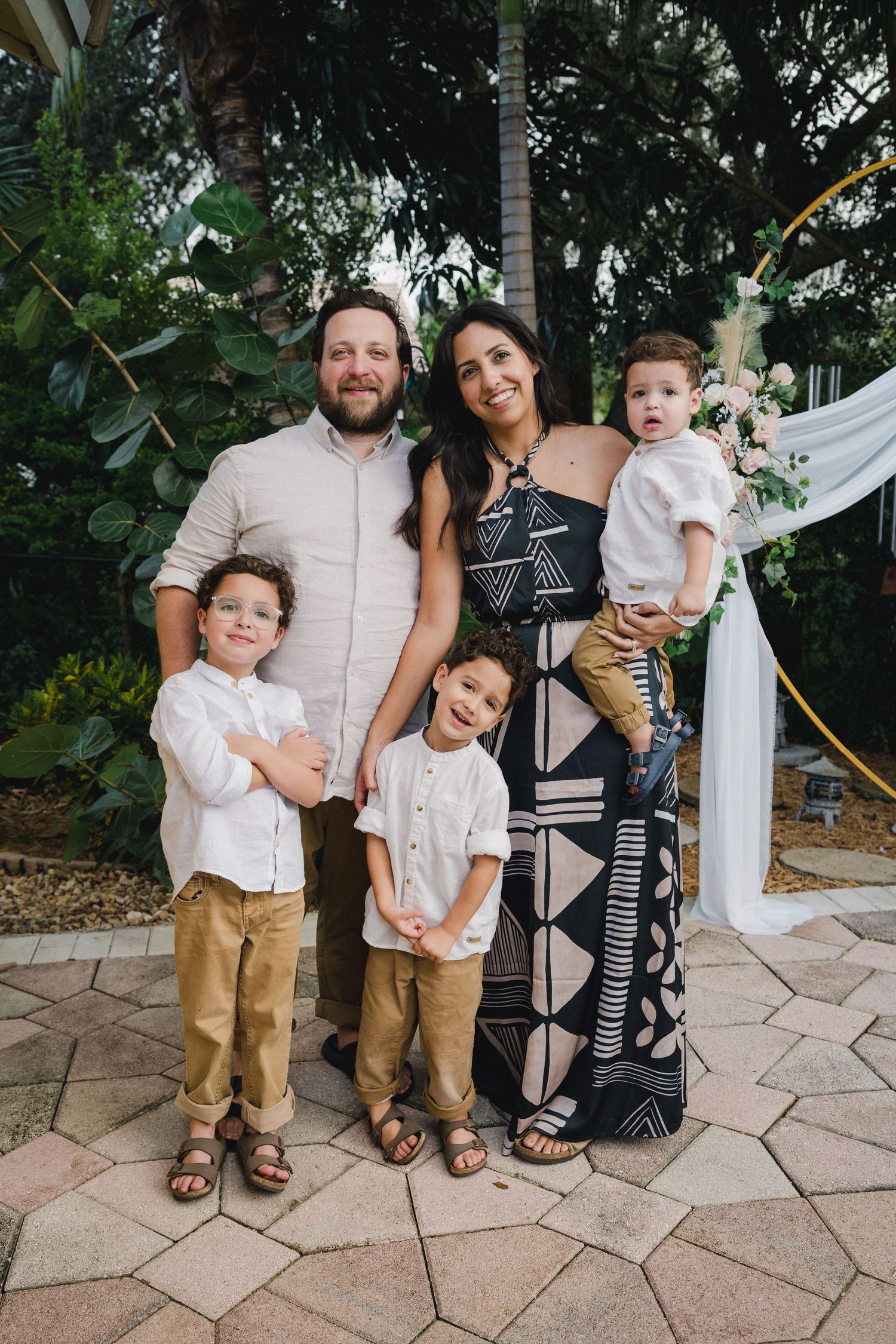 Family of four posing together at an outdoor lifestyle session by Bylitos Studio Michigan