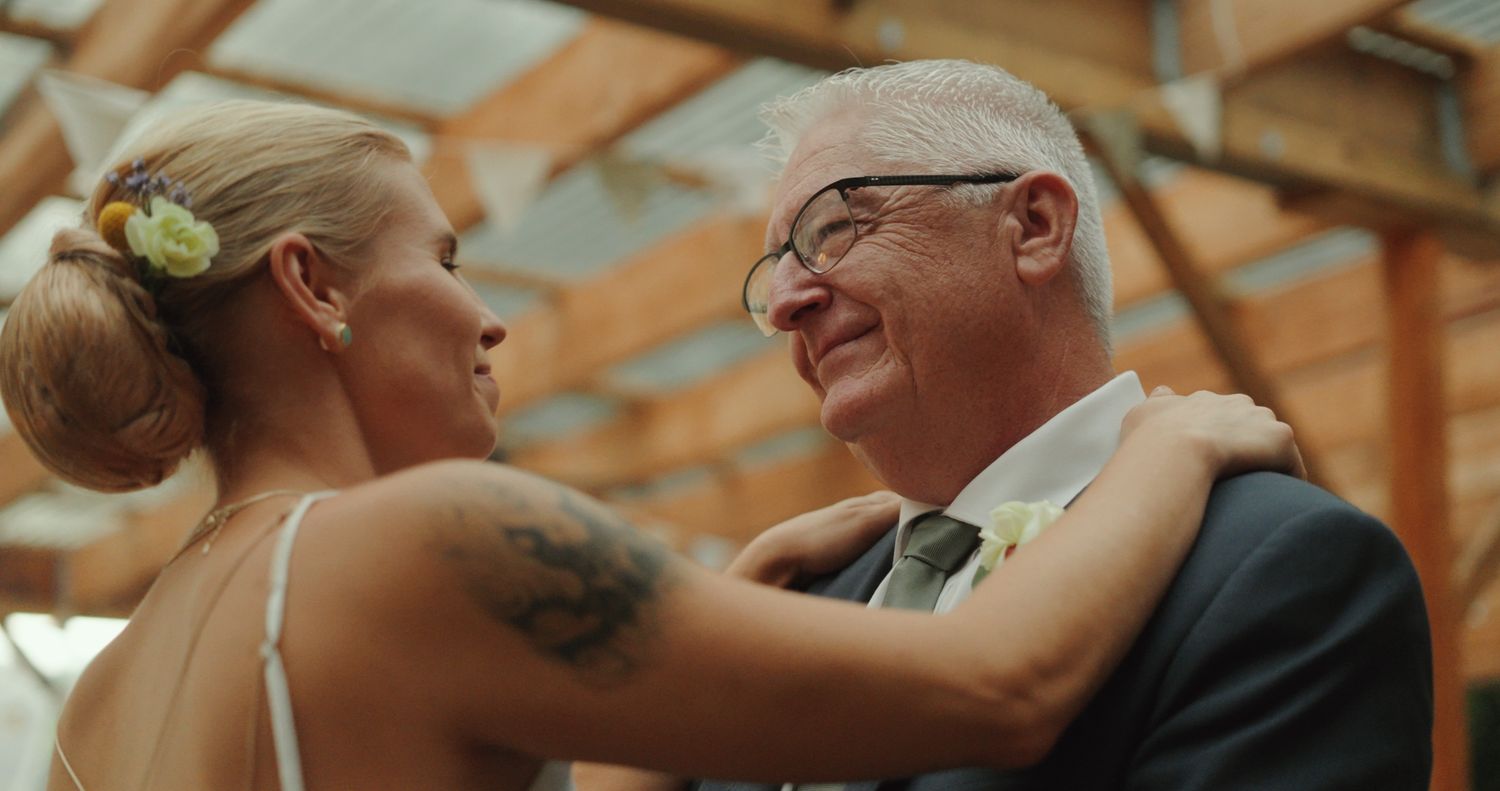 Bride sharing a joyful father-daughter dance moment at Michigan wedding reception by Bylitos Studio