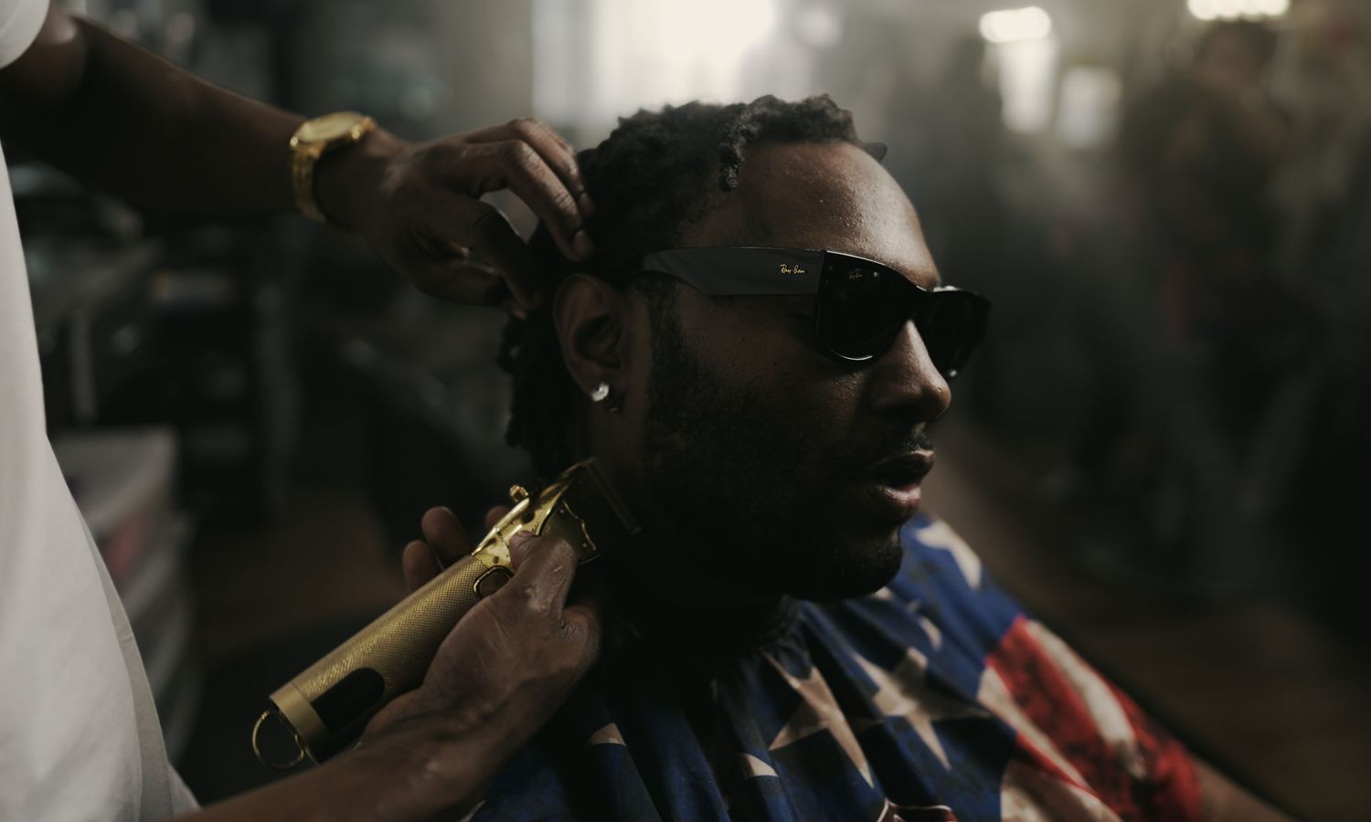 Cinematic portrait of man getting a haircut with gold clippers in dramatic lighting by Bylitos Studio Michigan