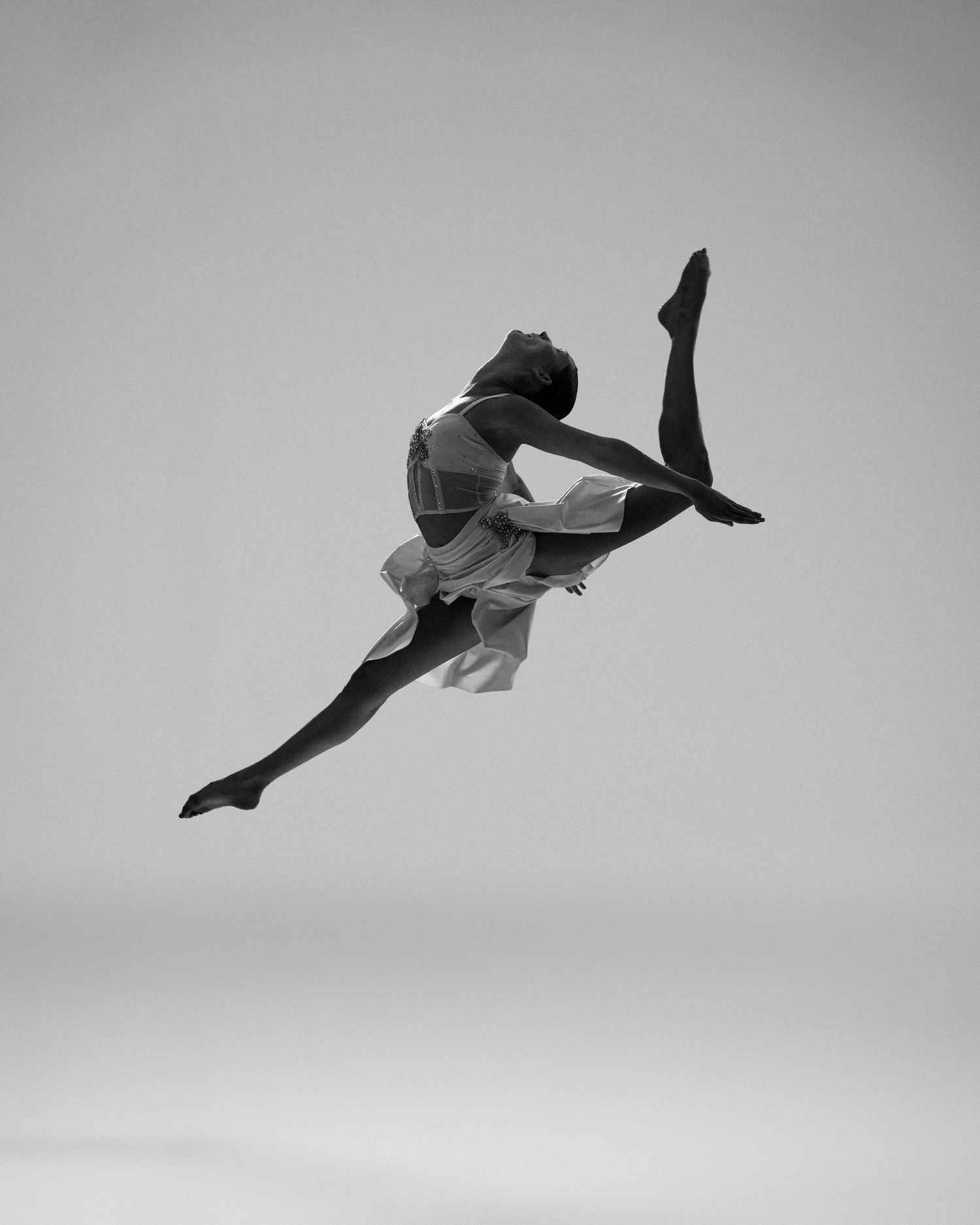 Dancer mid-leap in dramatic black and white studio editorial by Bylitos Studio Michigan