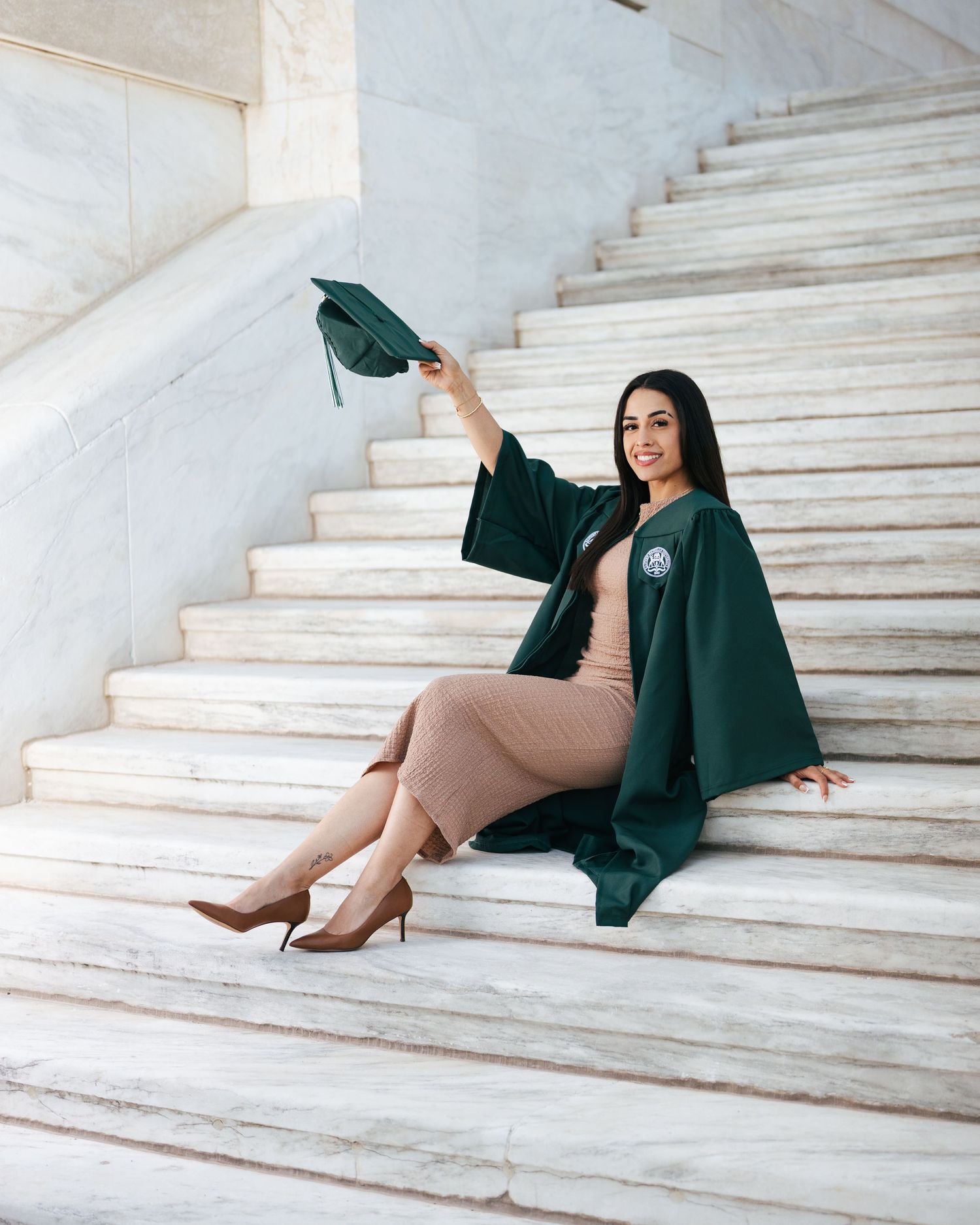 Woman in teal dress seated on outdoor marble steps in editorial portrait session by Bylitos Studio Michigan