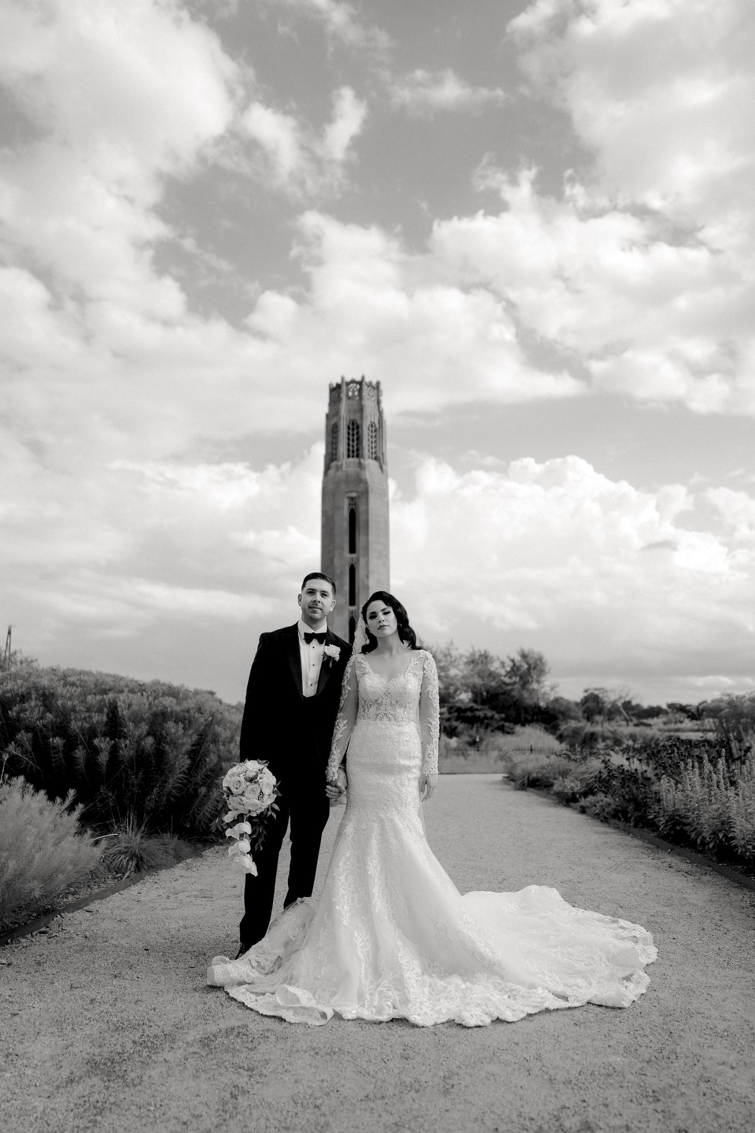 Black and white wedding portrait of couple in front of a Michigan landmark tower by Bylitos Studio Michigan