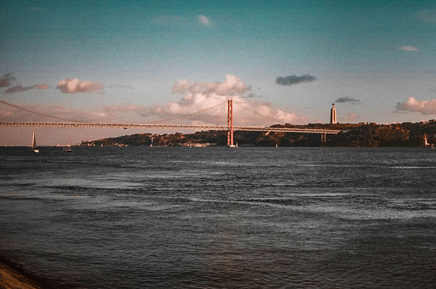 25 April Bridge silhouetted against a sunset sky over Tagus River in Lisbon, Portugal.