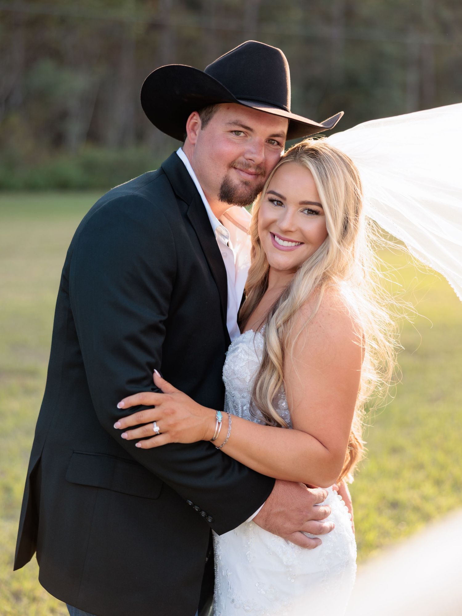 A couple shares intimate romantic moments in a rustic outdoor setting during a golden hour wedding photoshoot.