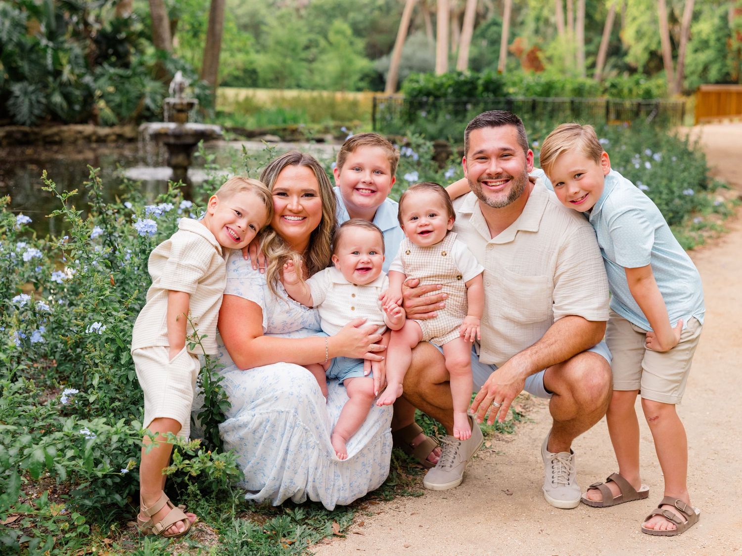 Family outdoor photoshoot series with coordinated white outfits and casual poses in a natural setting.