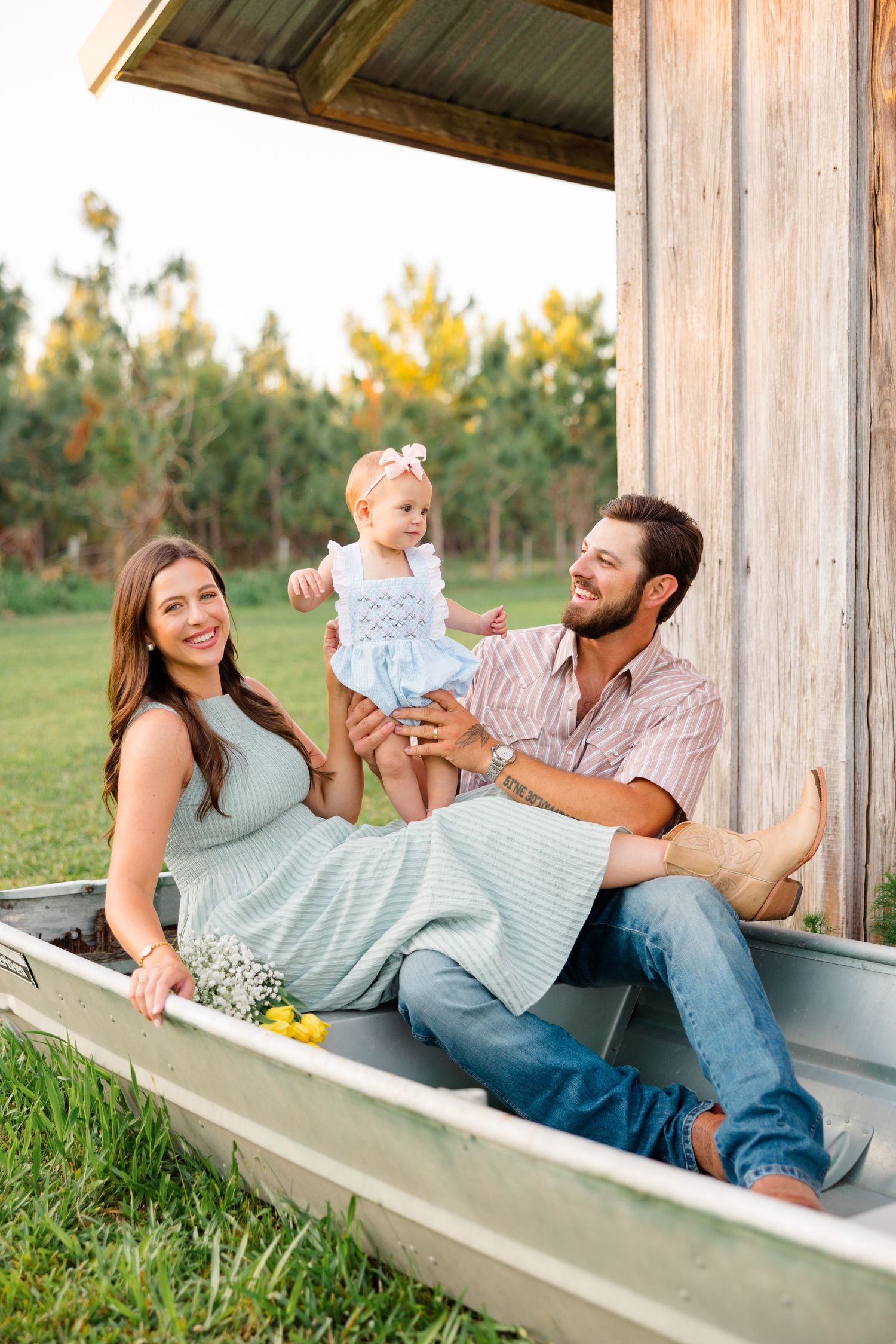 Happy family relaxing together on a wooden porch swing at sunset.