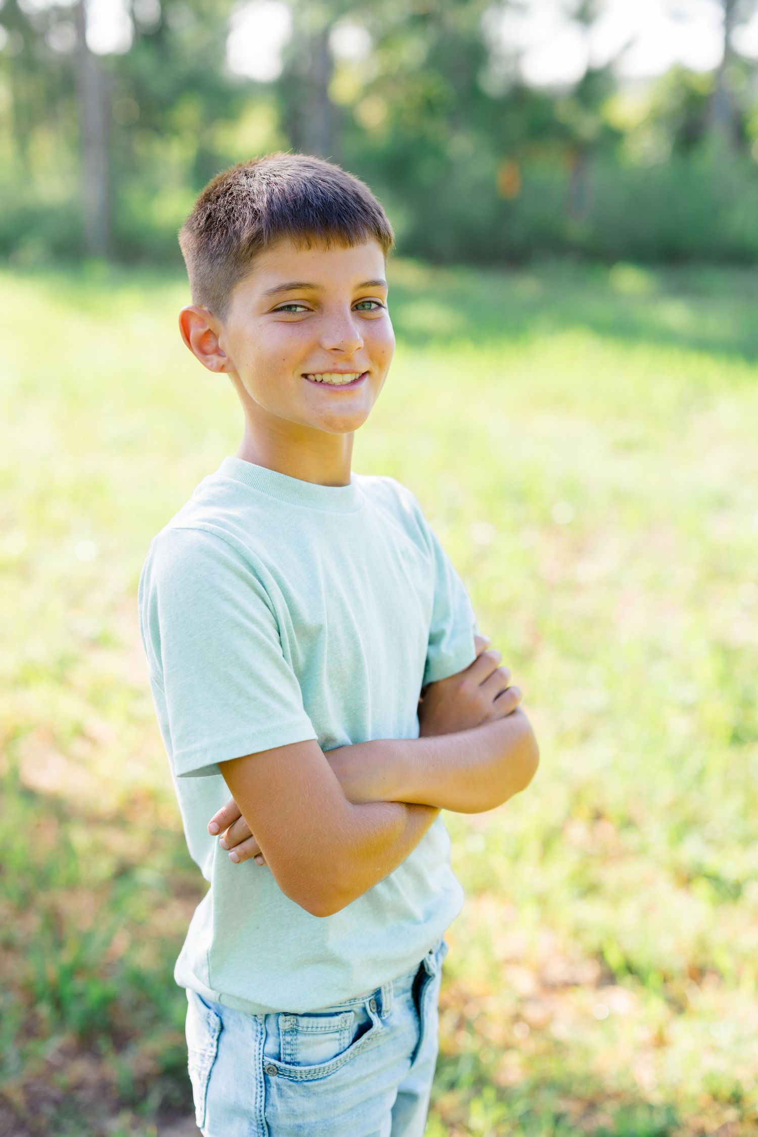 Portrait of a young person in casual attire smiling confidently outdoors.