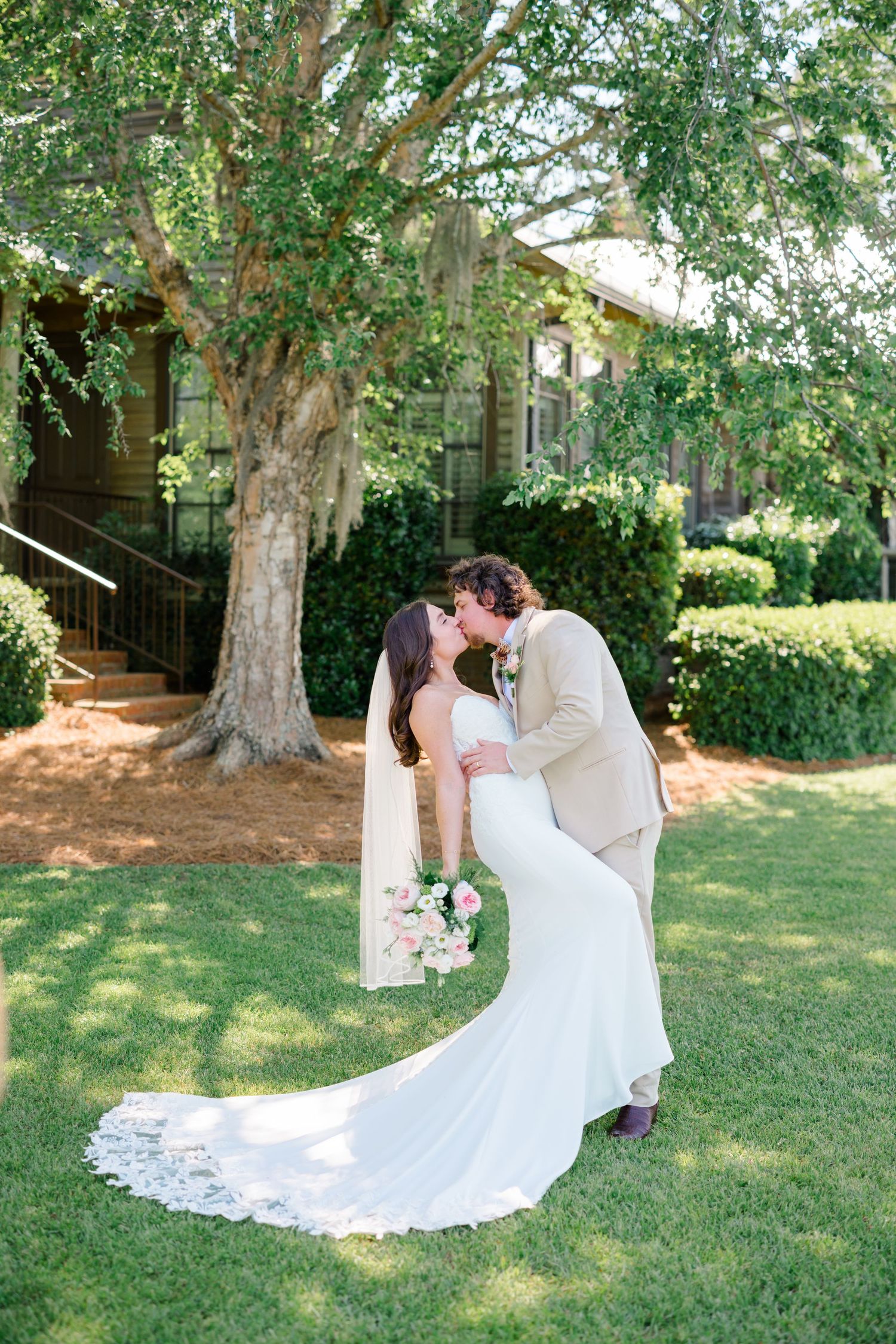 Wedding couple portraits under trees with flowing white dress and romantic poses.