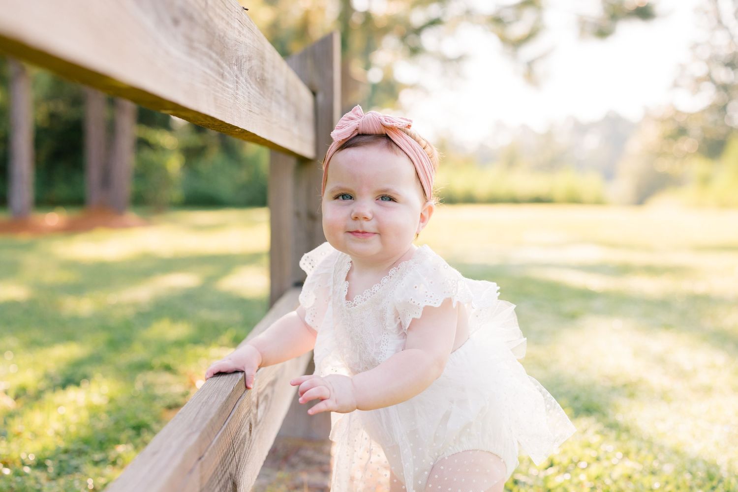 Sweet baby portraits captured in natural sunlight wearing delicate white and pink outfits.