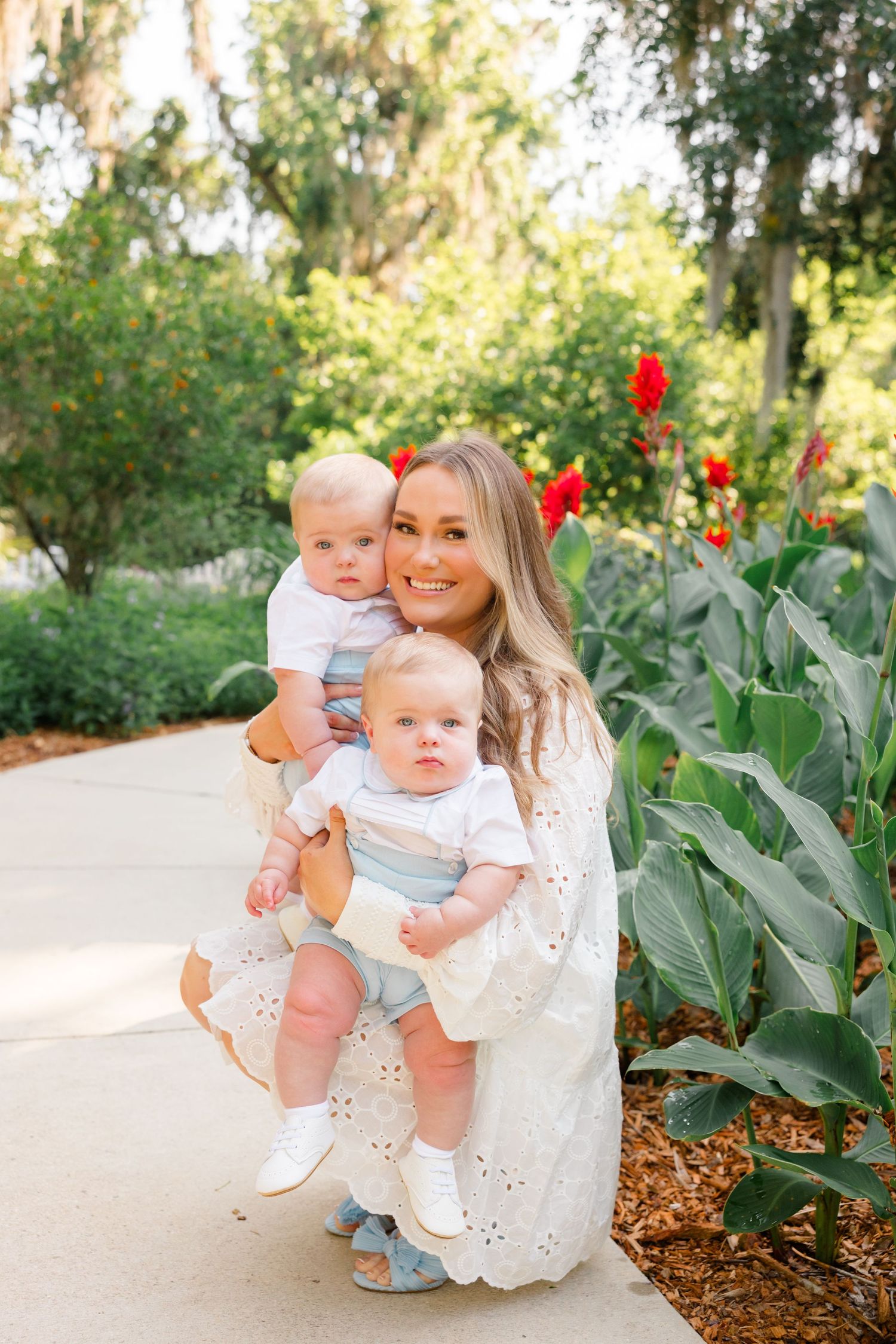 Beautiful garden photoshoot with tropical plants and decorative red accents in background.