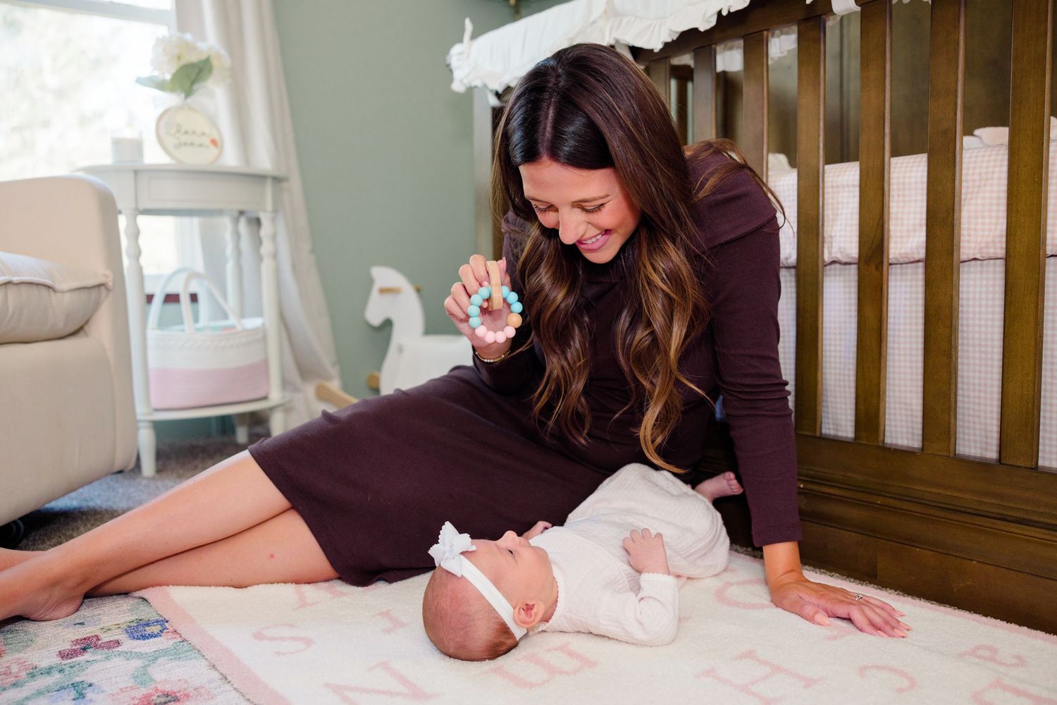 Indoor lifestyle photoshoot of baby on crib mattress with brown bedding.