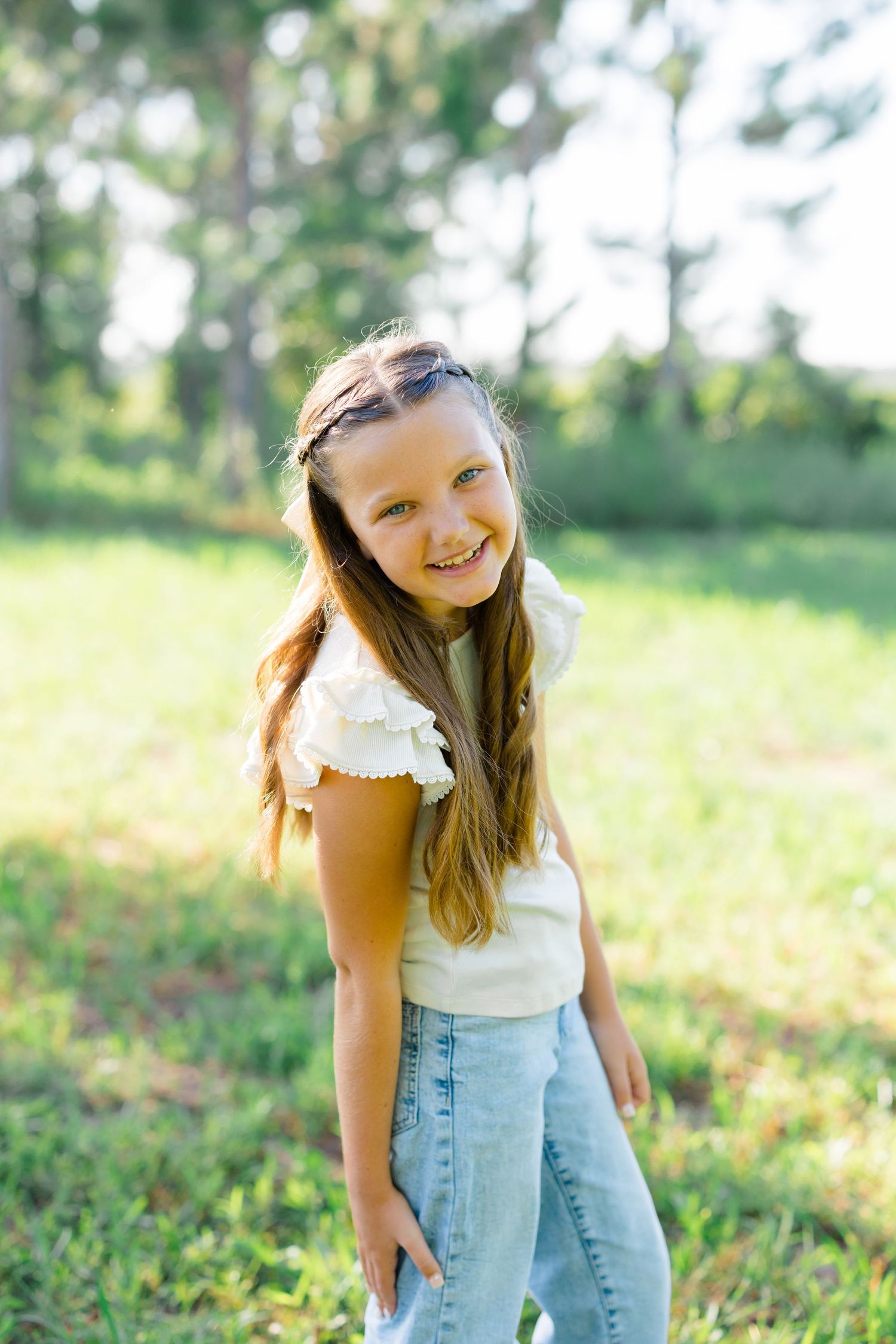 Candid portrait of a young person laughing in casual summer attire outdoors.