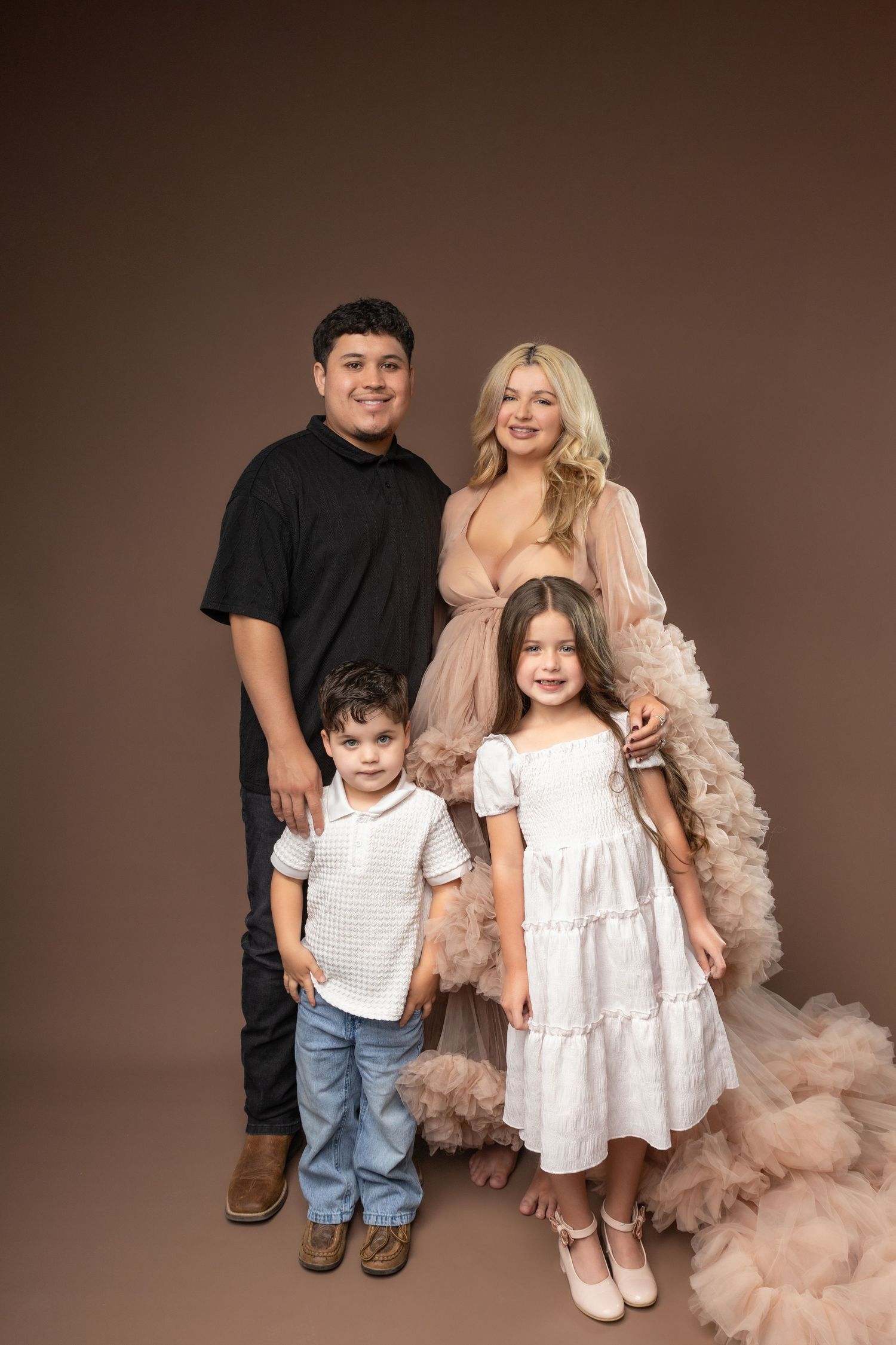 Studio portrait series showing siblings in coordinated outfits against a brown backdrop with flowing tulle details.