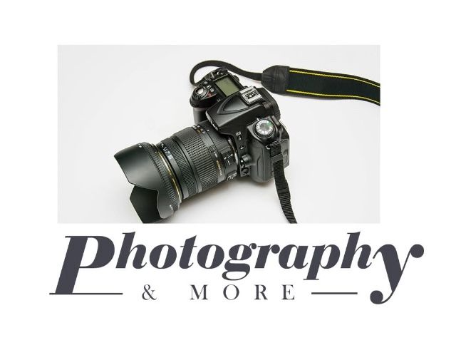 Professional DSLR camera with lens being held against black background showing photography equipment details.