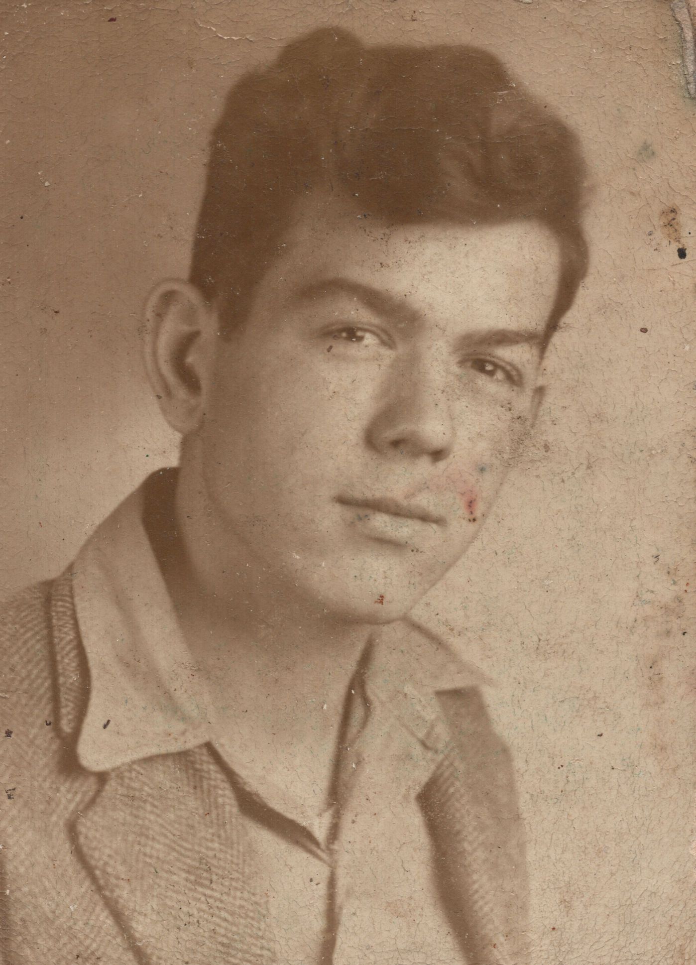 Vintage sepia portrait photo of a young man with dark hair wearing a collared shirt, classic mid-20th century style.