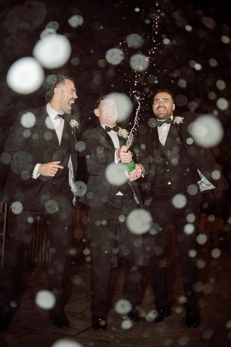 Nighttime celebration with champagne bottle spray and formal attire creating a magical atmosphere at West Tower wedding venue.