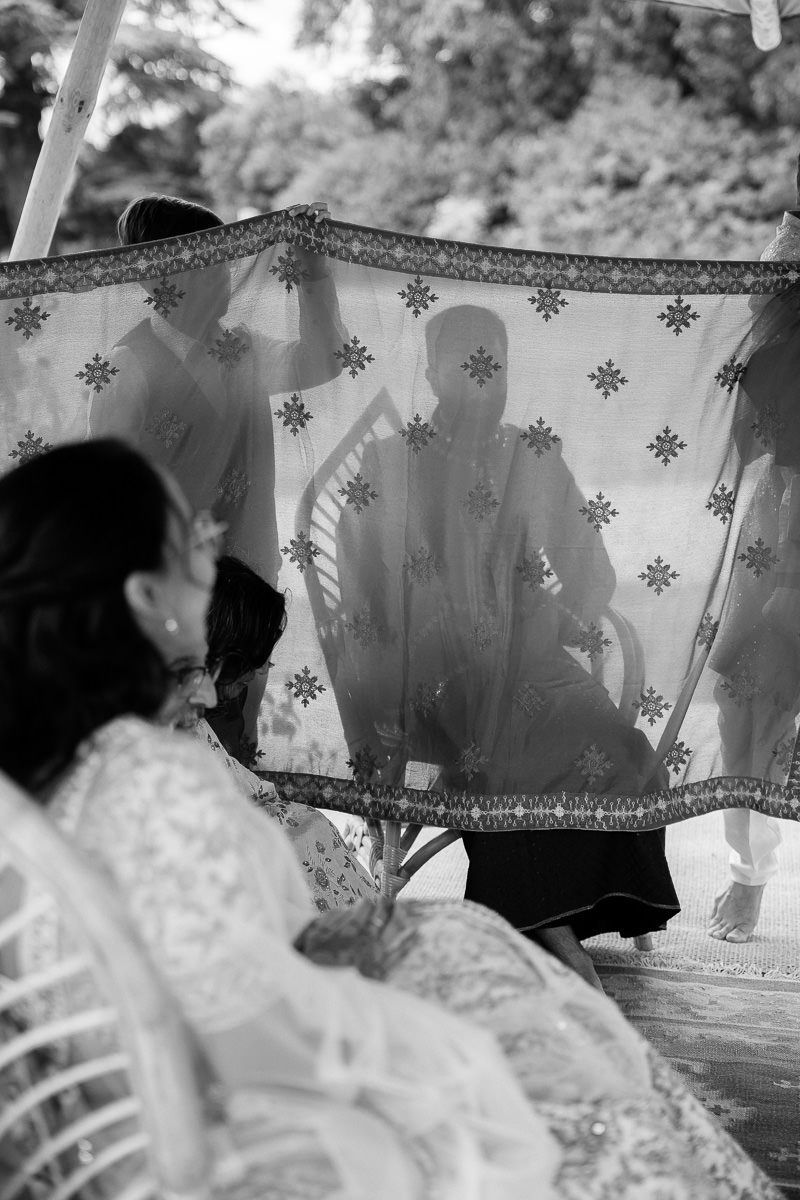 Silhouettes of wedding guests behind a translucent screen decorated with snowflake patterns.