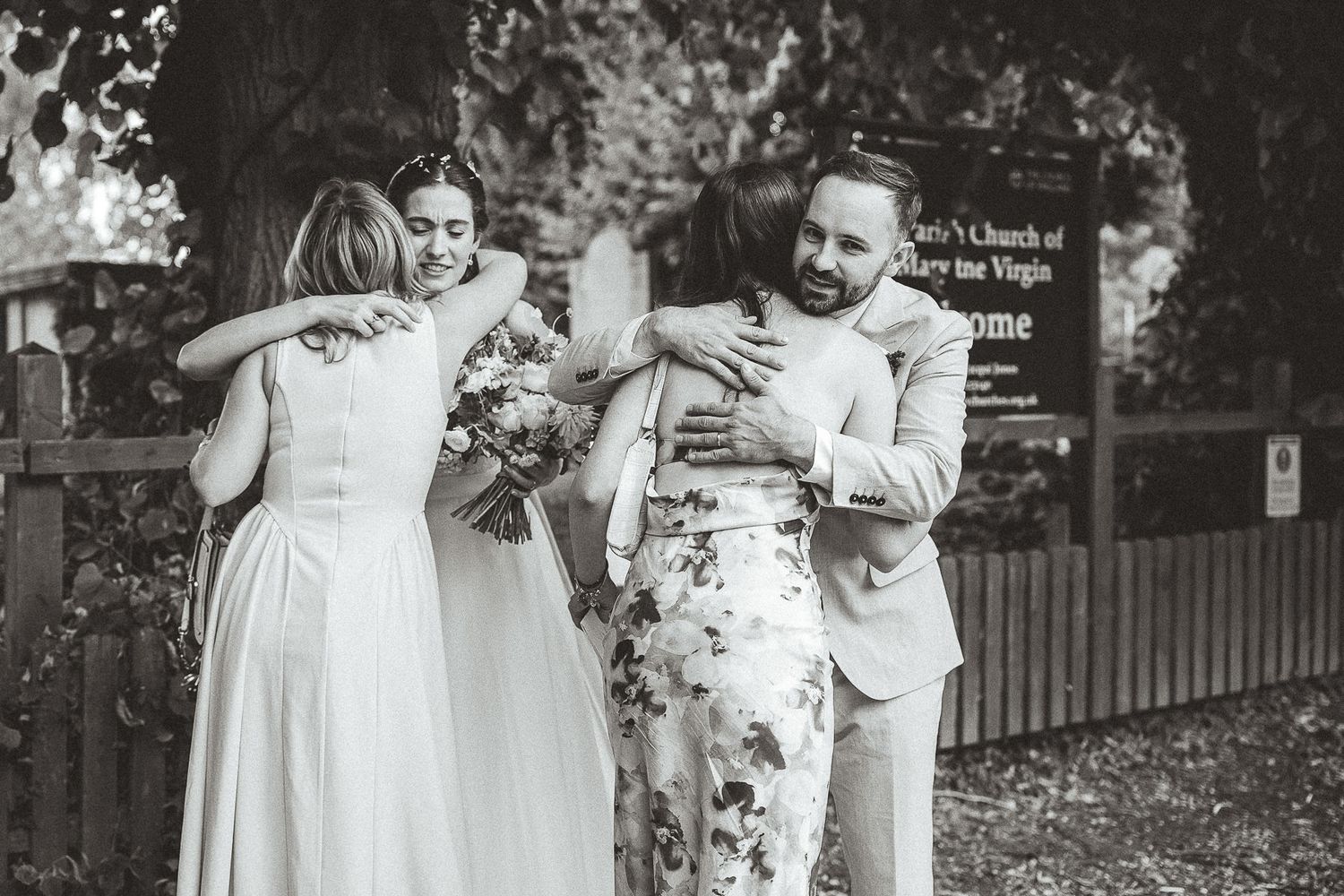 Black and white photographs show a joyful wedding celebration outdoors with people in light-colored formal attire.