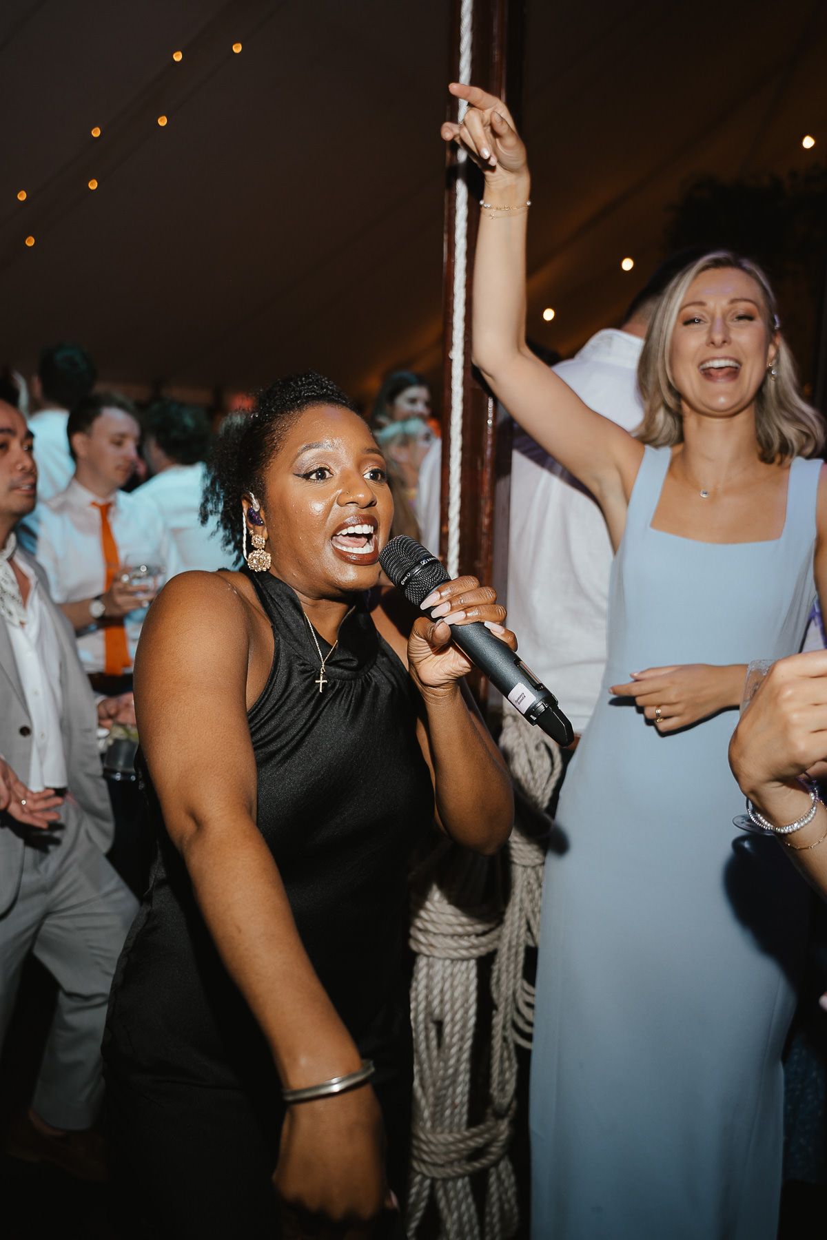 Wedding reception guests dancing and celebrating with enthusiasm at a lively indoor party venue.
