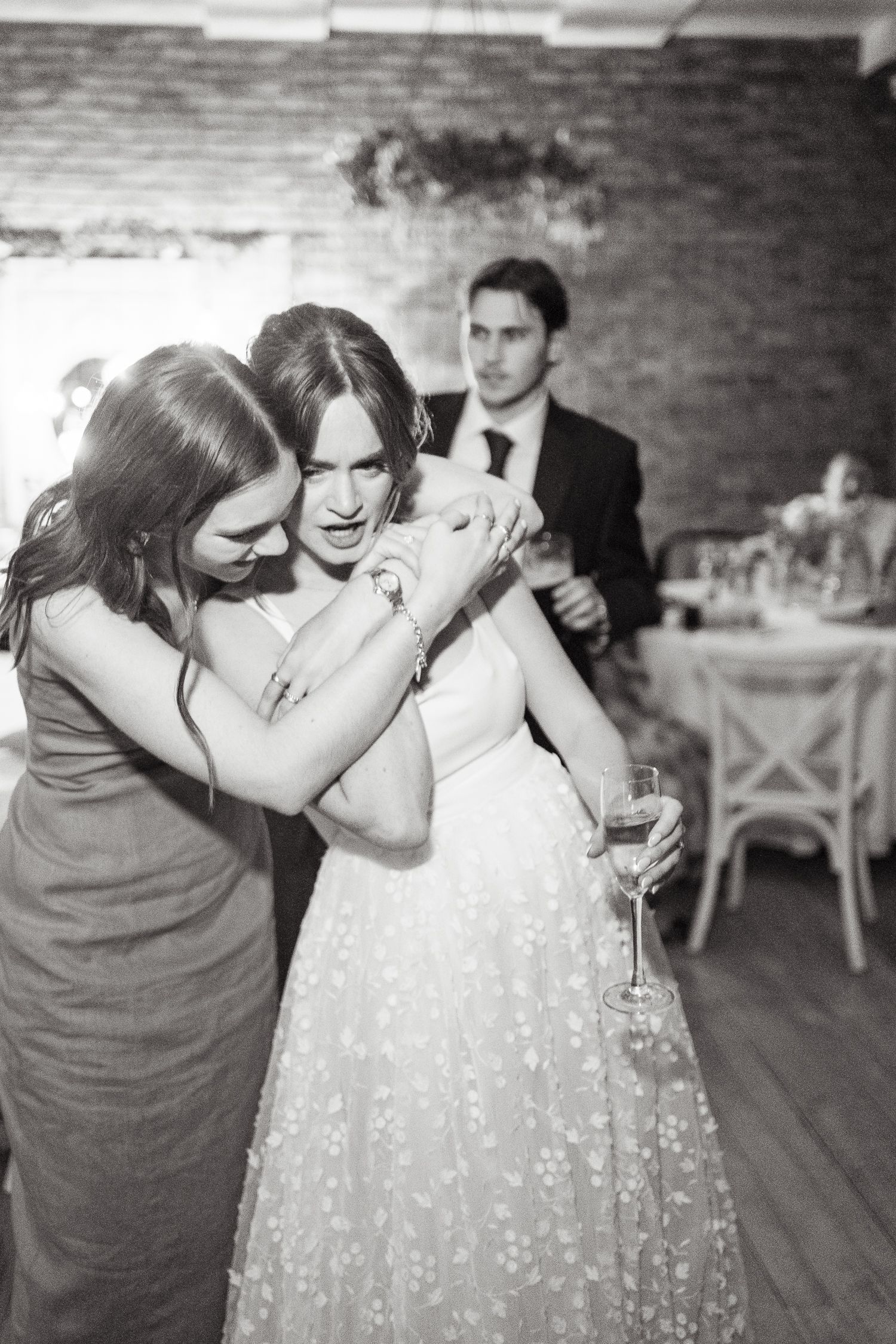 An emotional sequence of black and white photos shows a touching moment between two people at a wedding reception.