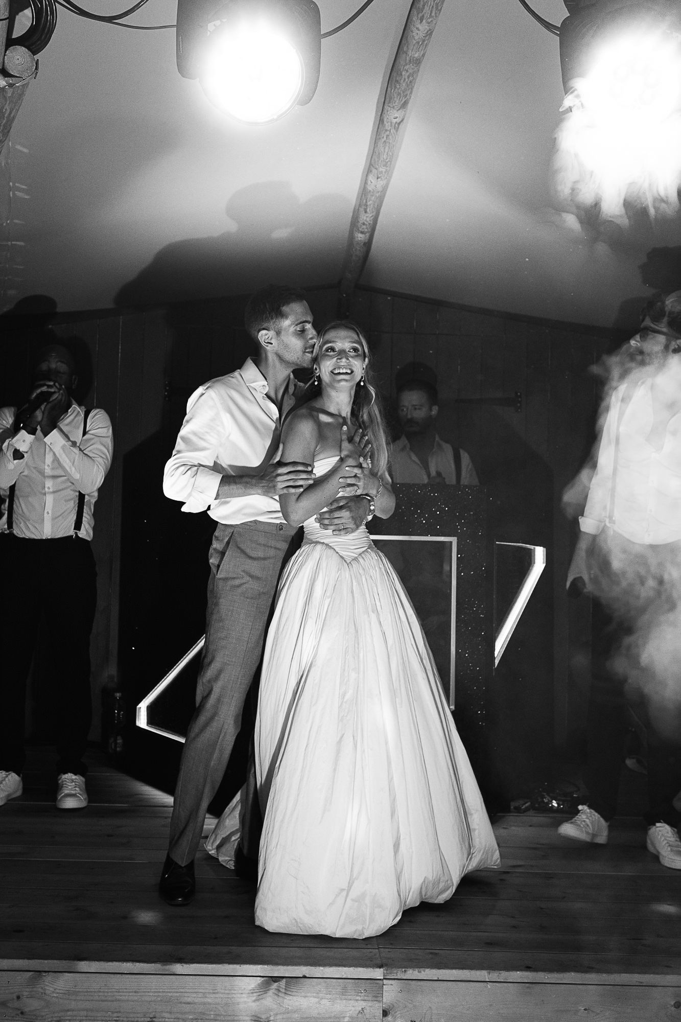 Black and white photo of a bride and groom sharing their first dance at a wedding reception.