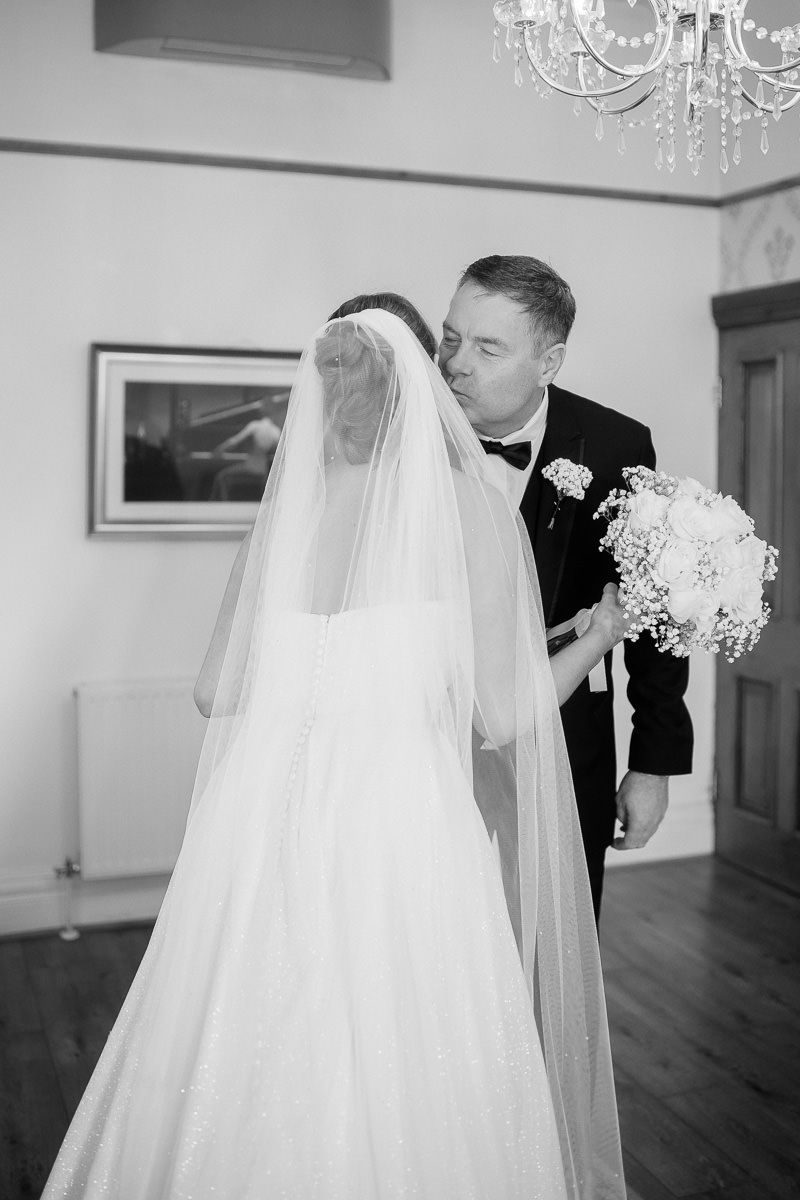 Black and white wedding photo sequence showing a bride in flowing veil and groom dancing together in an elegant room.