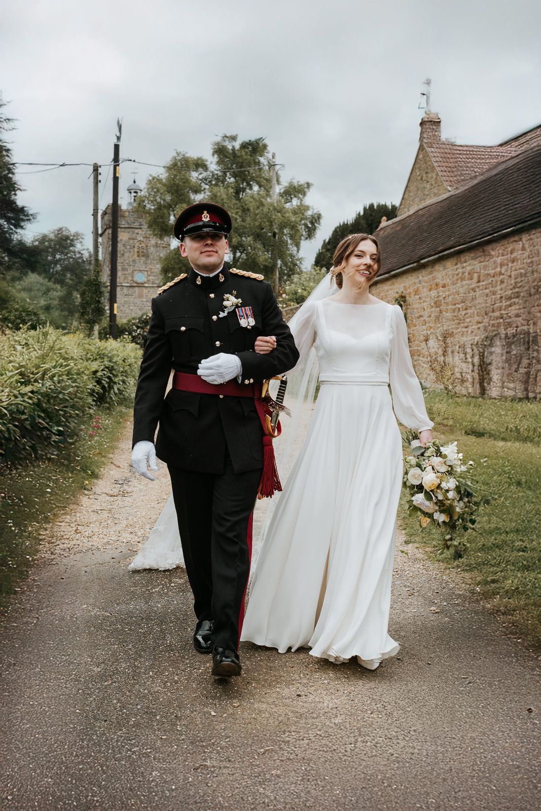 A series of wedding photos showing a couple walking on a rustic country lane in traditional military and bridal attire.