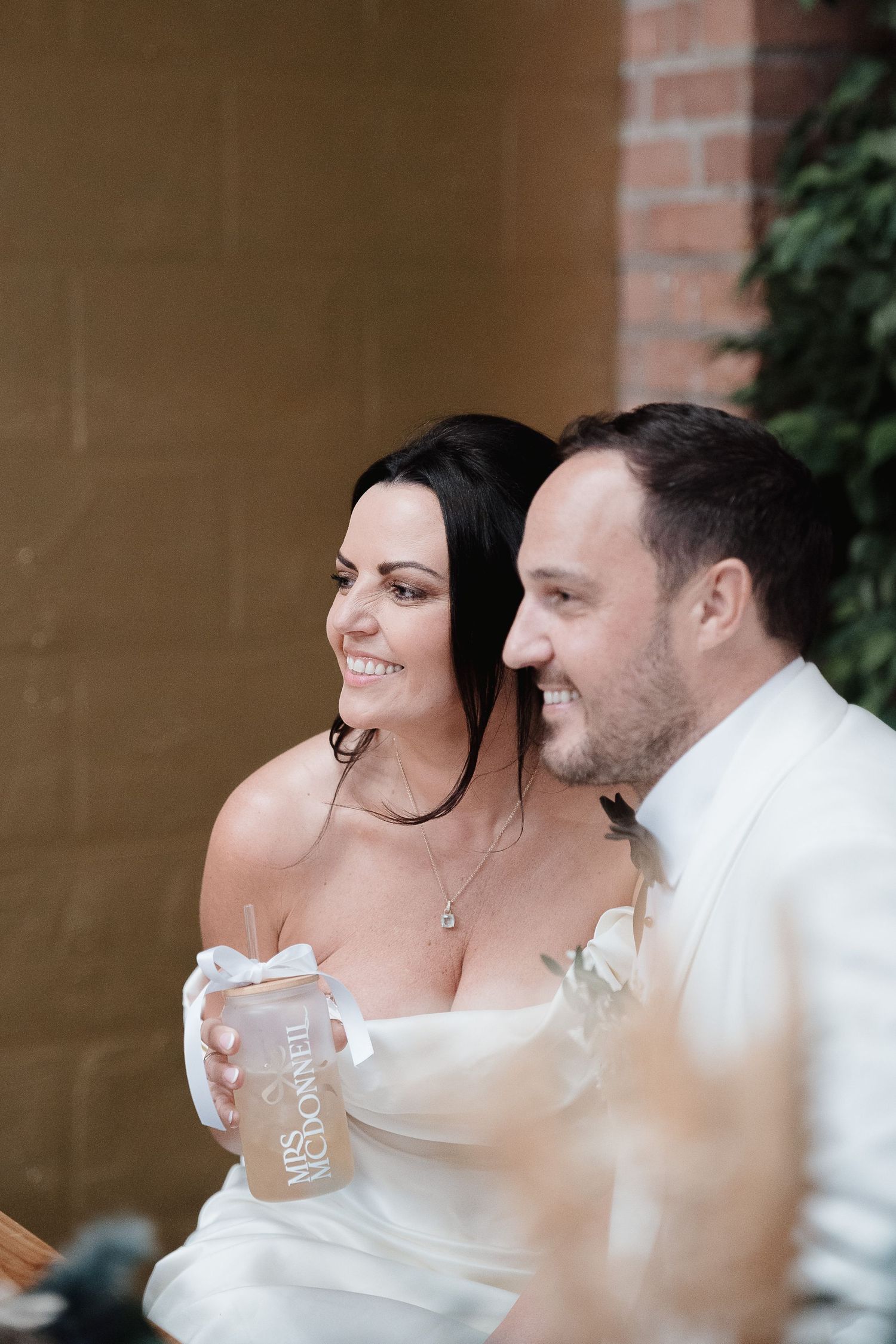 A couple shares an intimate moment during a wedding photoshoot on a sunny day.