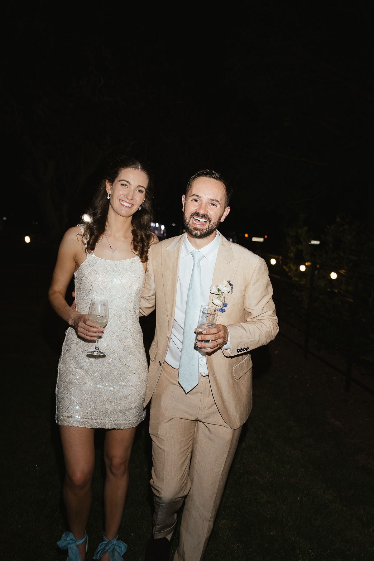 Newlyweds share laughs and cocktails while celebrating at their evening wedding reception.