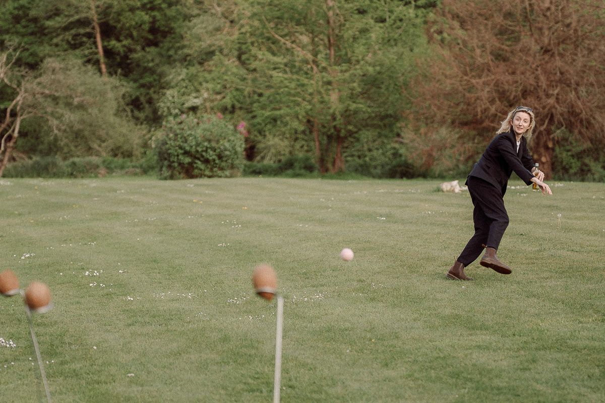 A sequence of images showing a football being kicked on a grassy field with trees in the background.