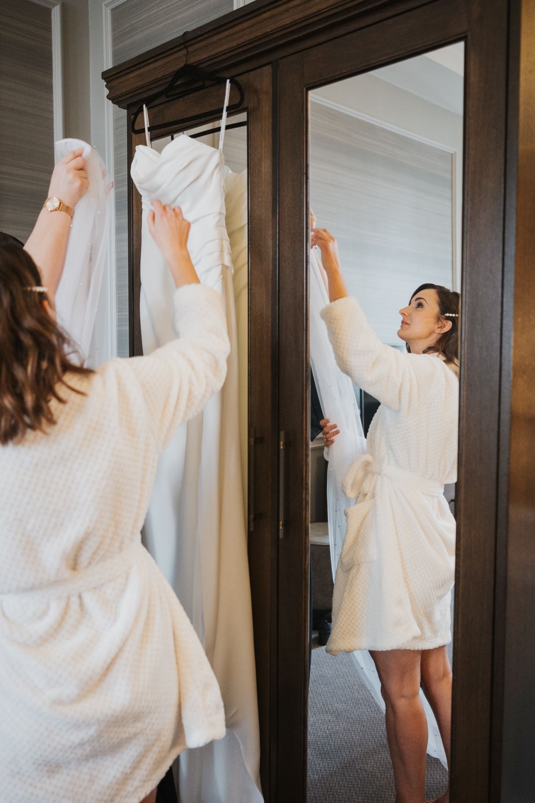 Person in white sweater robe looking up while facing dark wooden wardrobe in sequence of repeated photos.