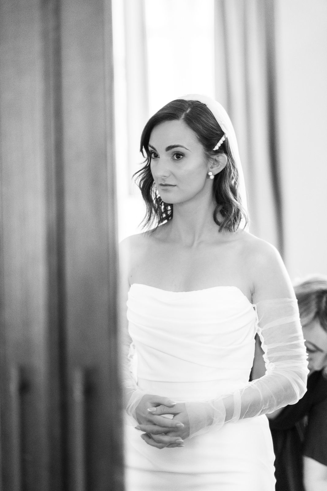 Black and white portrait series showing a woman in an off-shoulder white dress against a soft blurred background.