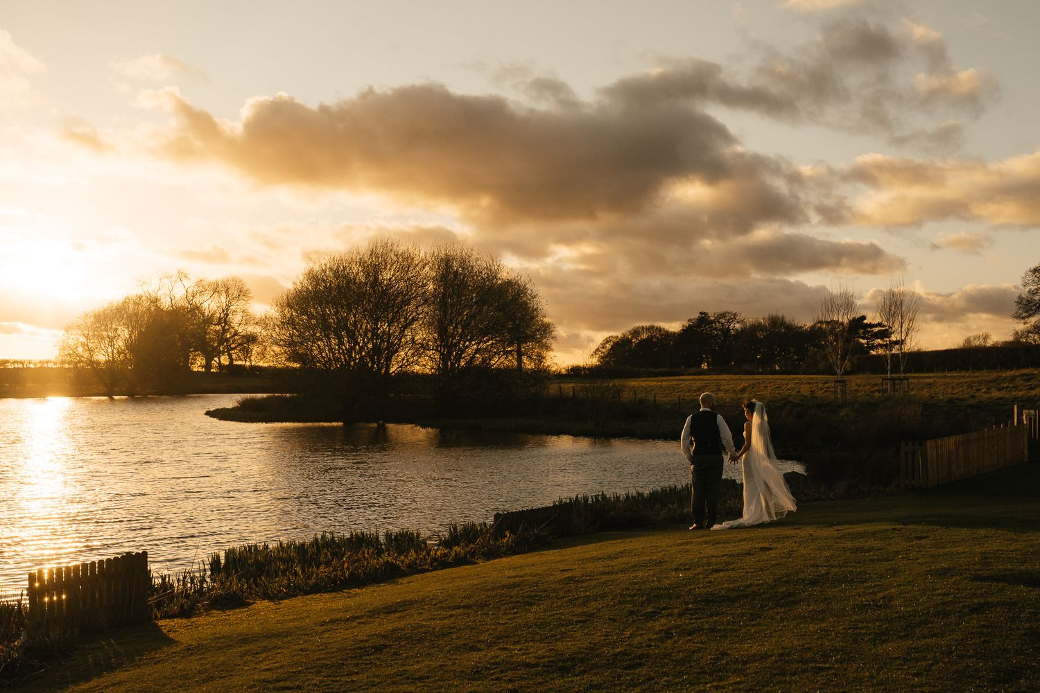 Panoramic sequence of silhouettes against a dramatic golden sunset sky over a coastal landscape with water views.