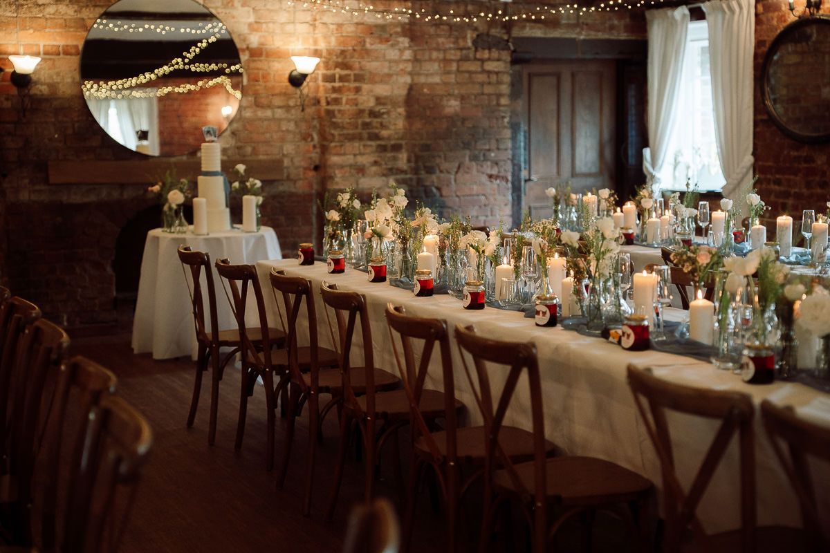 Rustic wedding reception venue with exposed brick walls and romantic string lights hanging overhead.