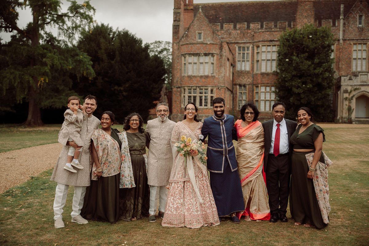 Wedding party group photo in front of historic brick building.