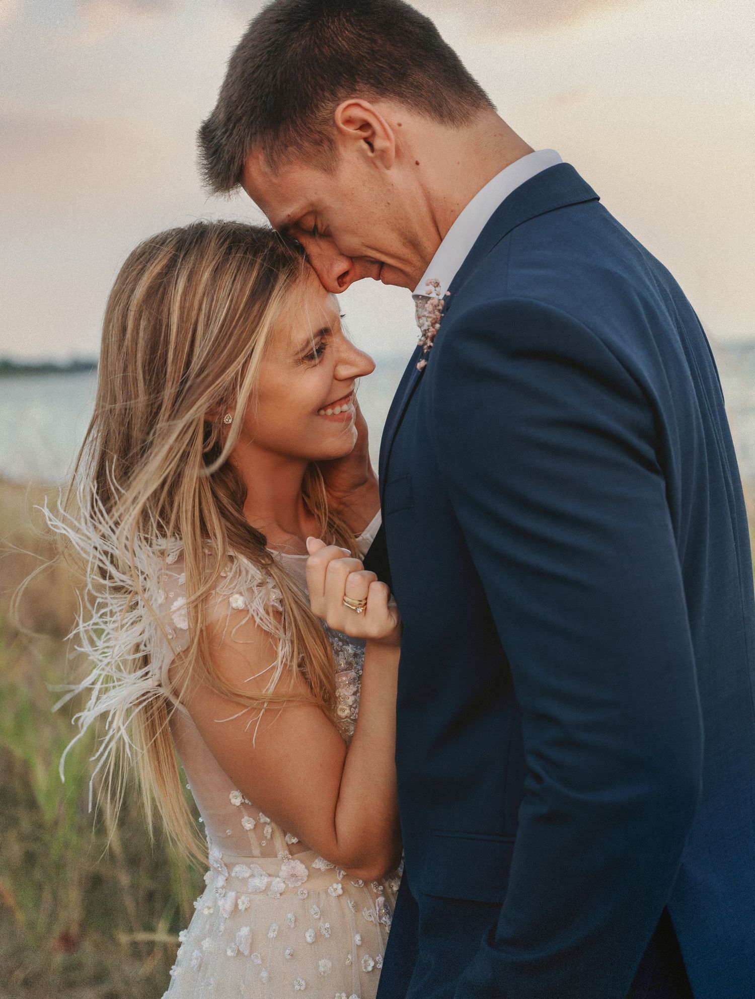 Intimate close-up wedding photography capturing a genuine, candid moment between bride and groom at sunset.
