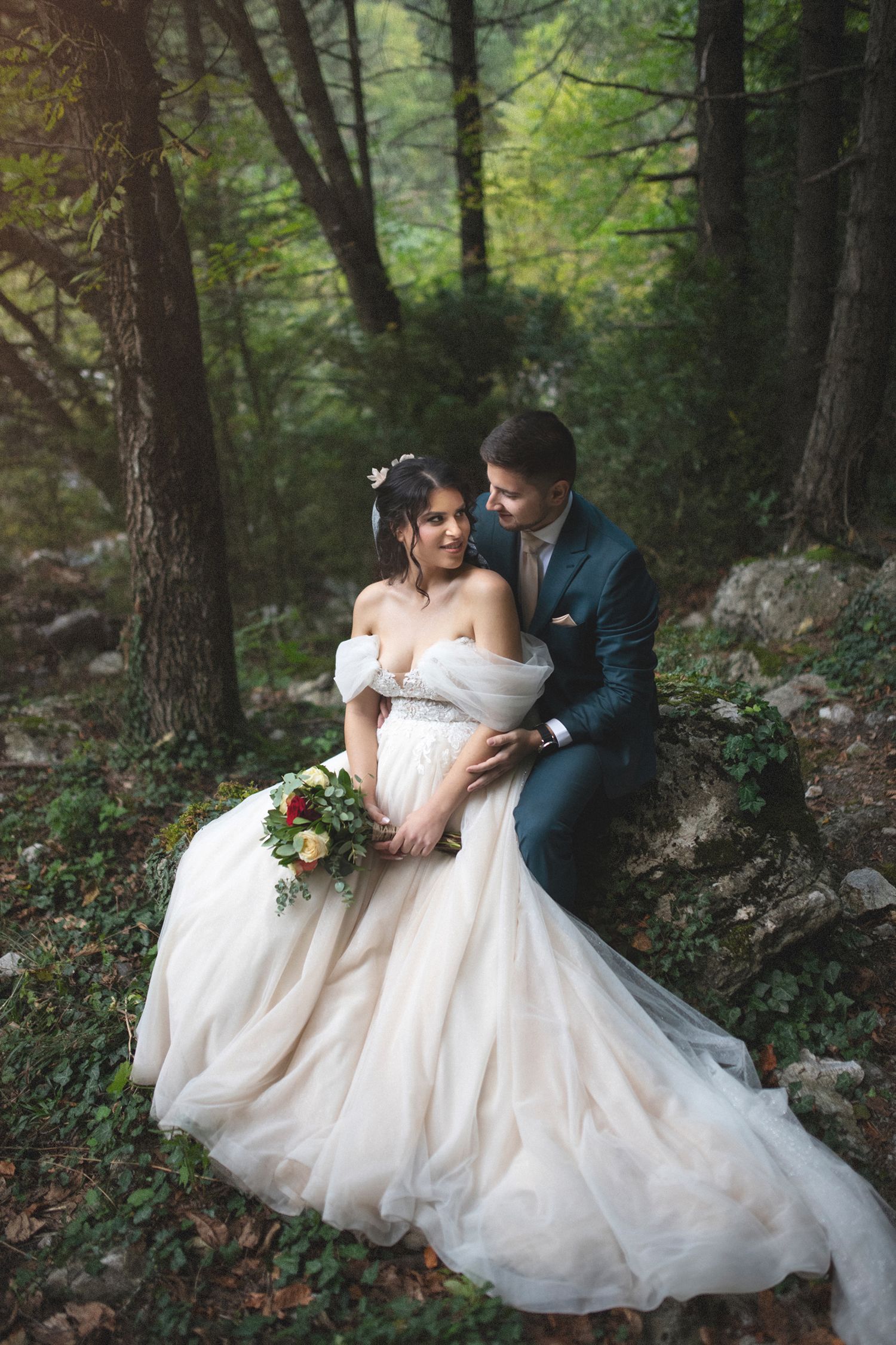 Documentary style outdoor bride and groom portrait highlighting a romantic off-the-shoulder wedding gown.
