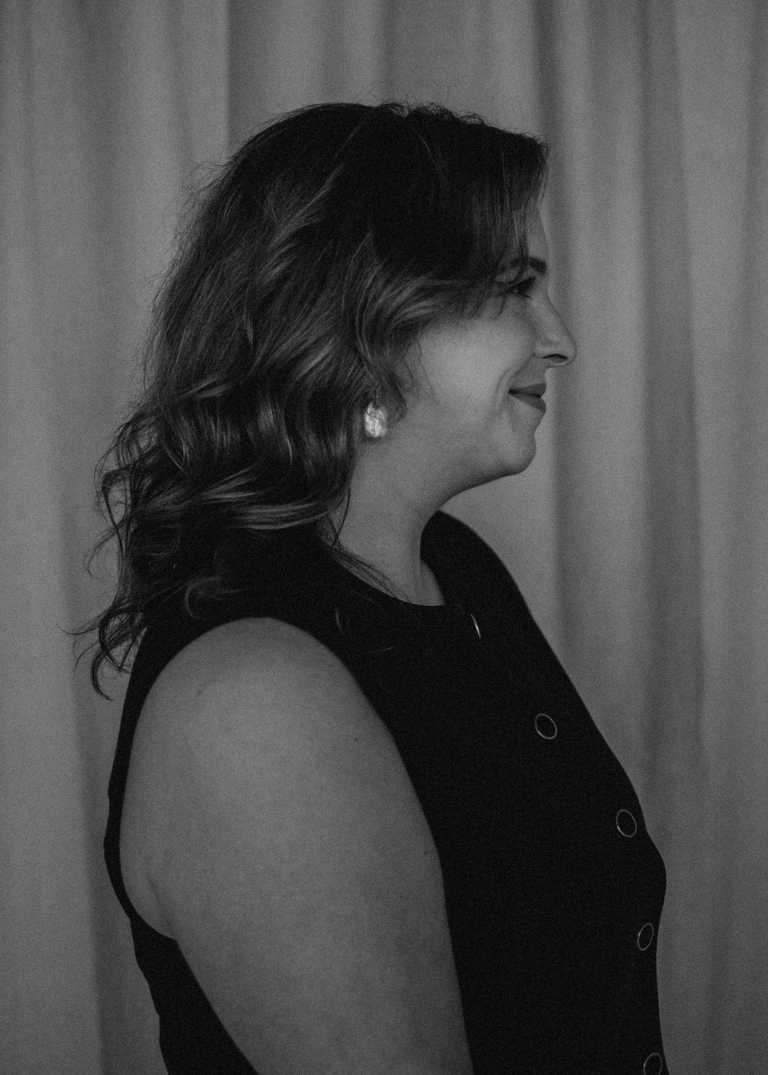 Black and white profile portrait of a woman with wavy hair wearing a sleeveless black top. Branding photoshoot in downtown Oklahoma City.