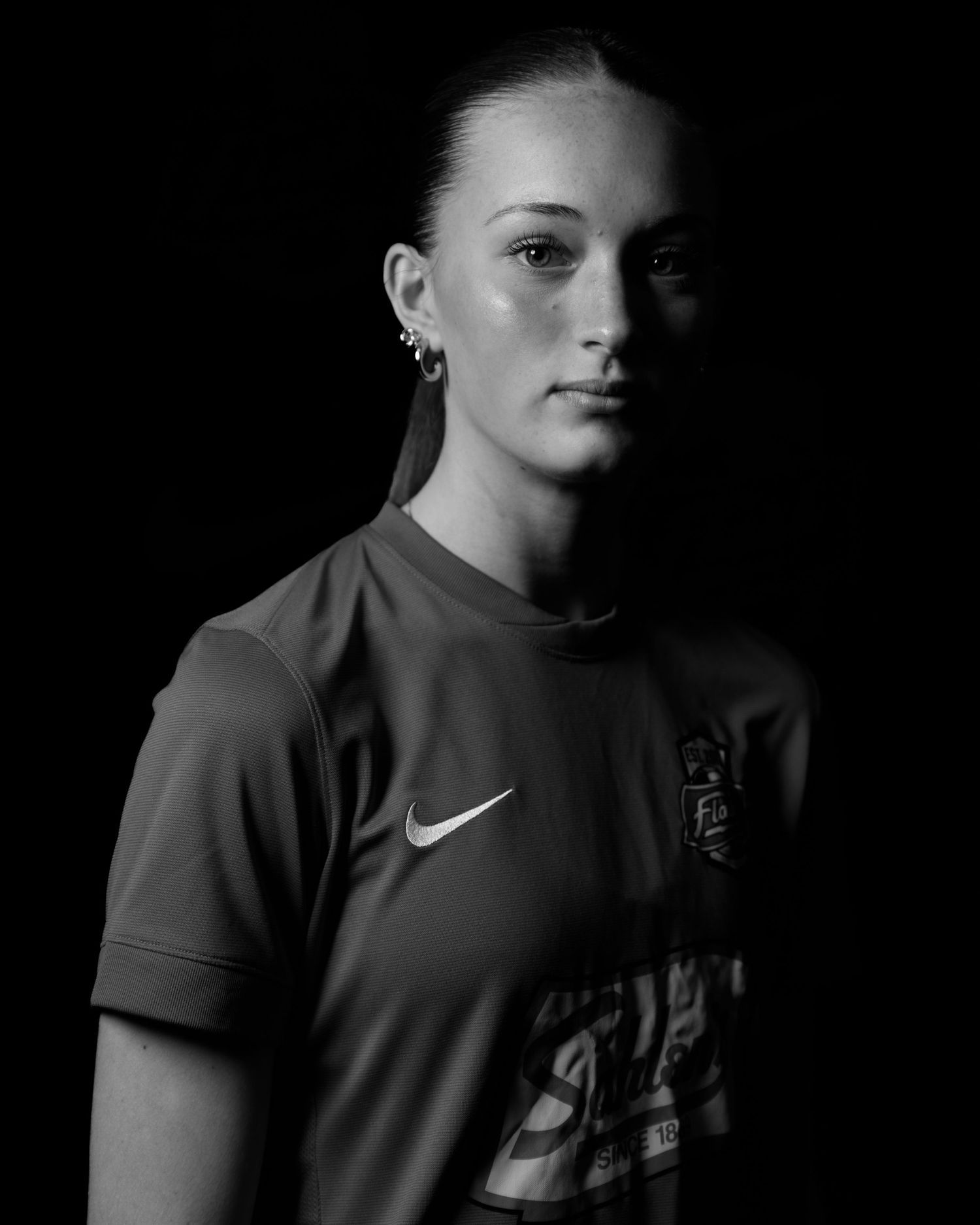 Black and white close-up portrait of a female soccer player wearing a Nike Flash jersey.