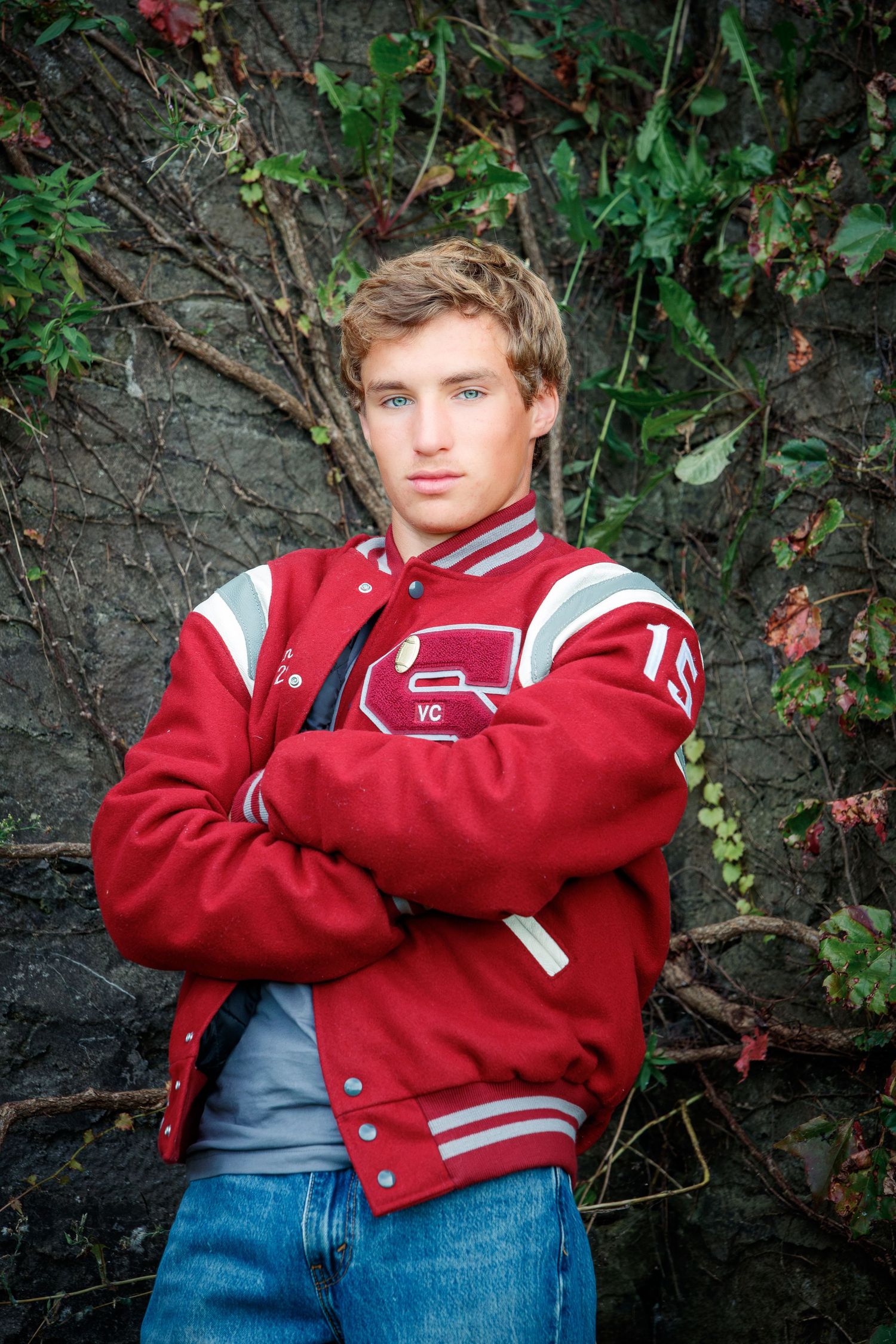 High school senior wearing a varsity jacket outdoors