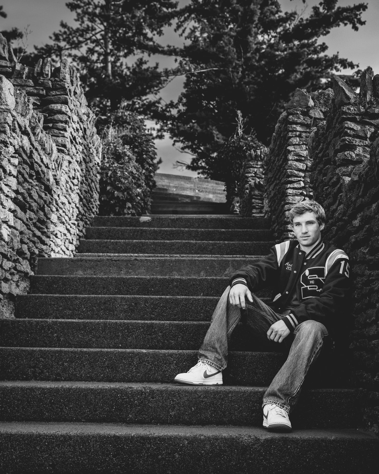 Black-and-white environmental senior portrait on stone stairs