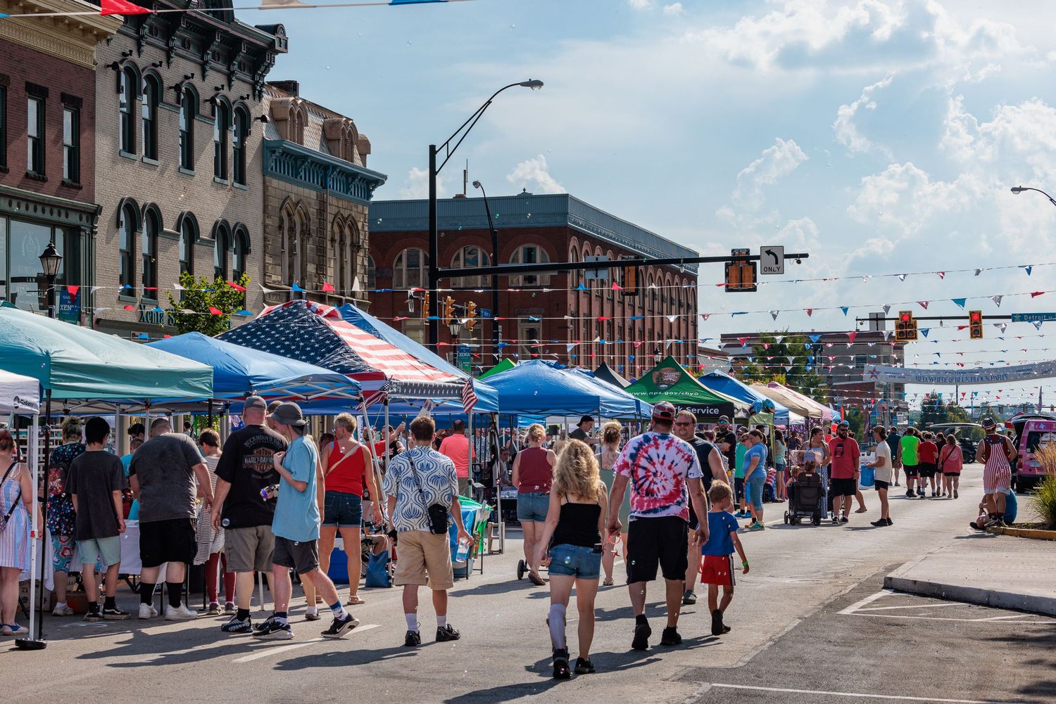 Festival attendees shopping at the booths of the red white and blue block party