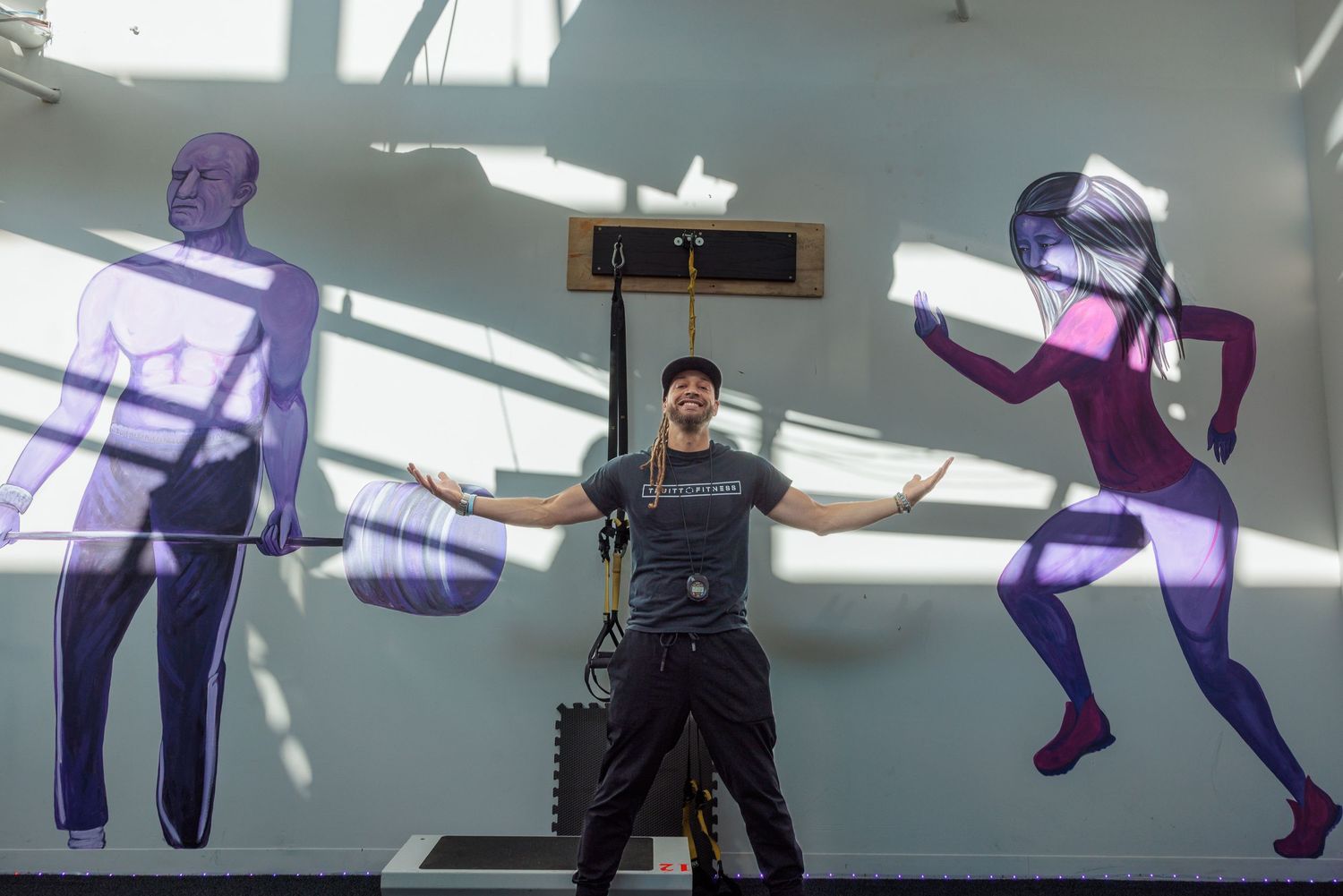 Kyle Truitt standing in front of a fitness mural at the new Truitt Fitness location in Yellow Springs.