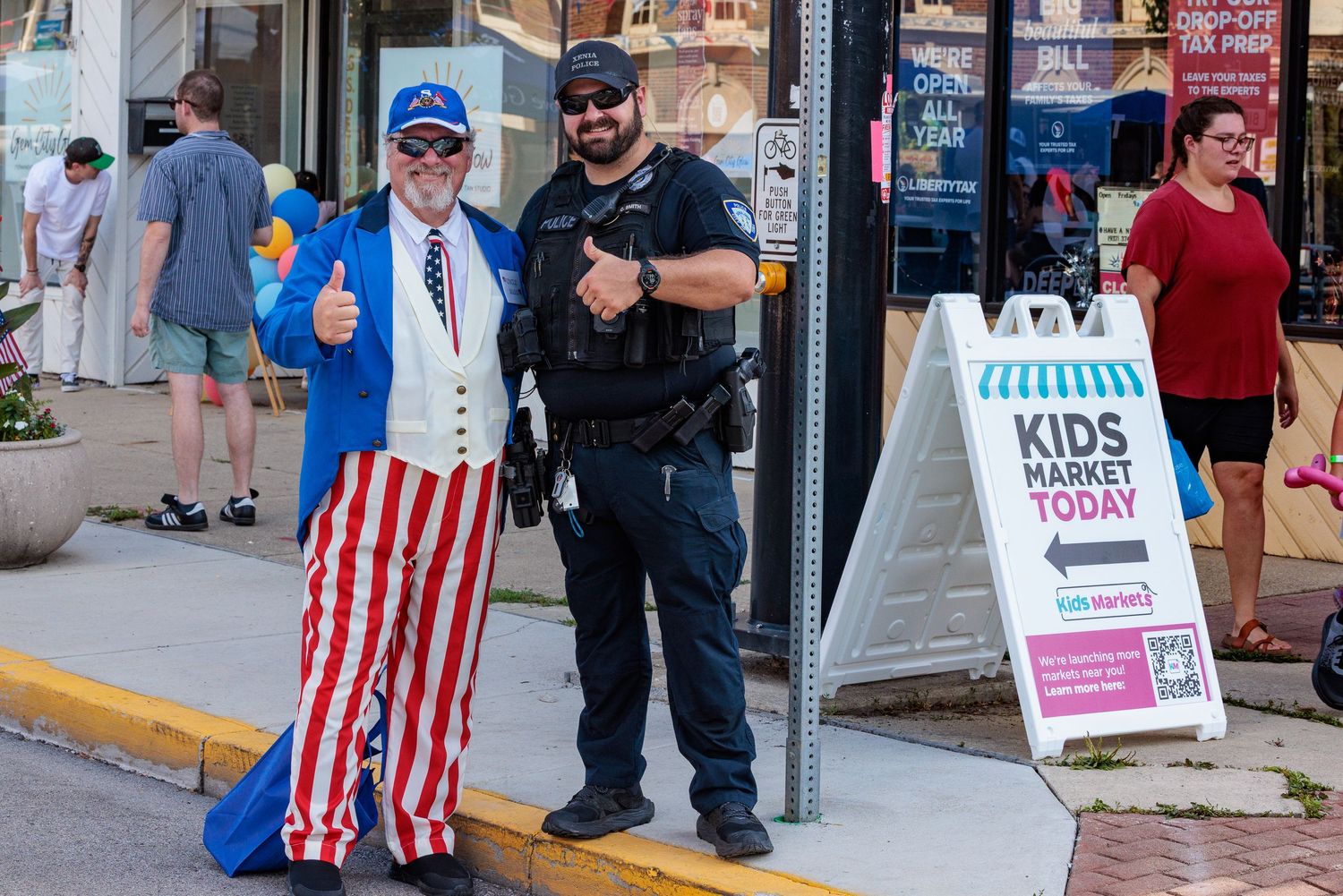 A Xenia police officer poses with a festival attendee dressed as uncle sam.