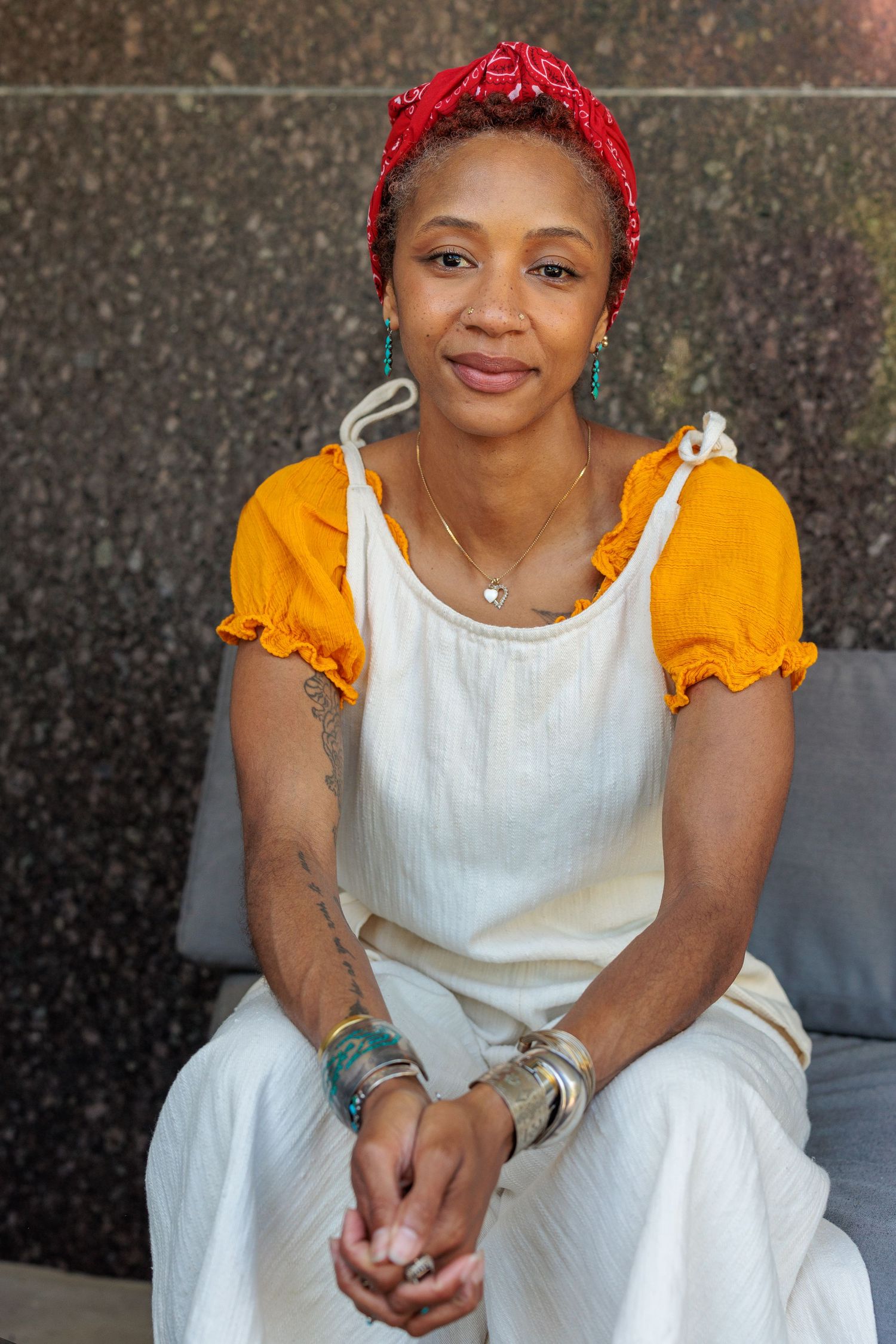 Portrait of Hyacinth seated against a stone wall, co-author of Points of Failure Vol. 1: Interwoven