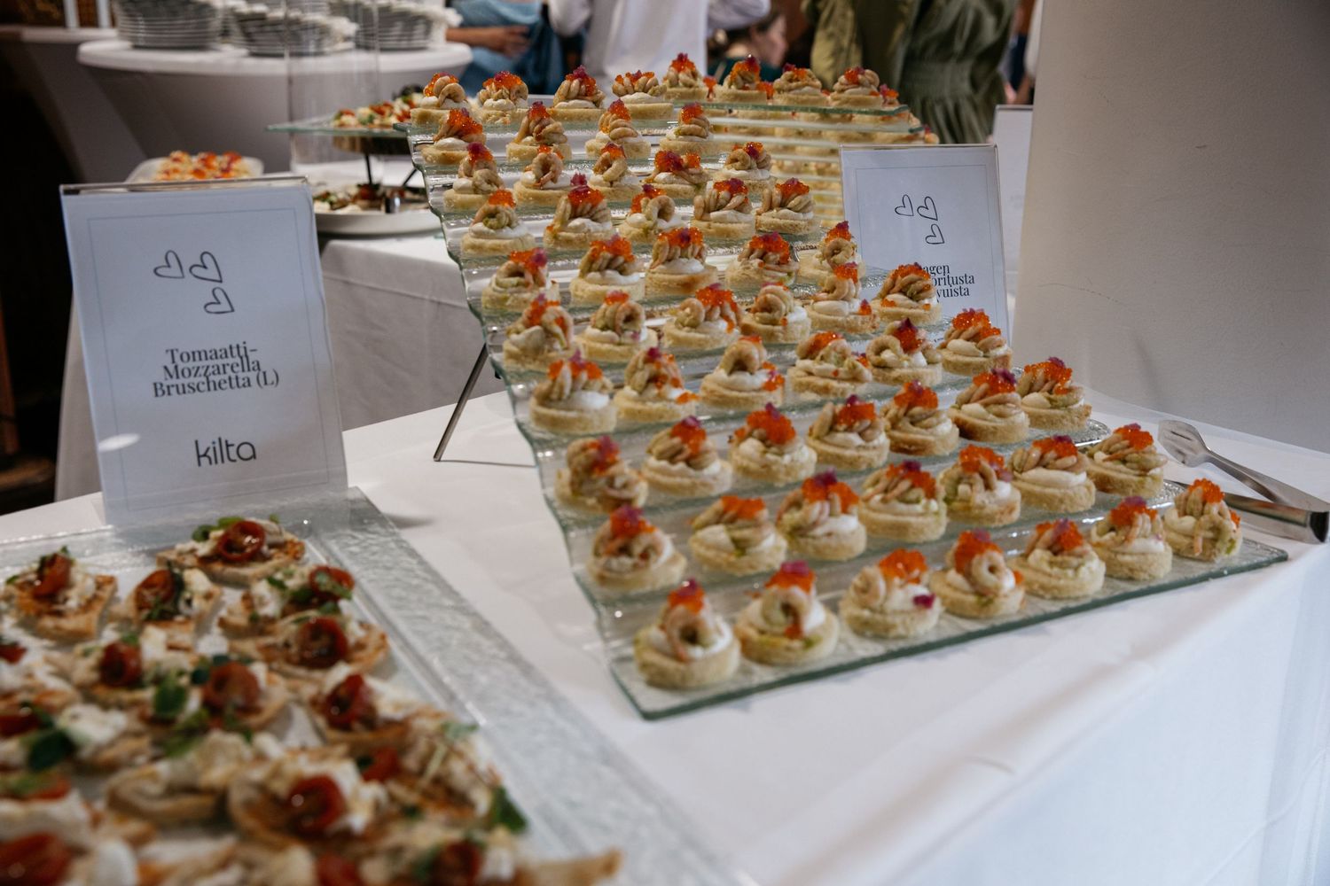 Elegant wedding canapés display with layered trays of bite-sized appetizers at a reception event.
