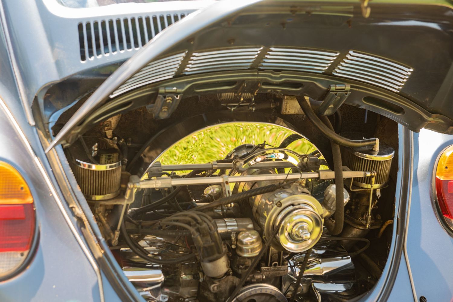 Rear engine bay of a classic blue Volkswagen Beetle showing the air-cooled flat-four engine.