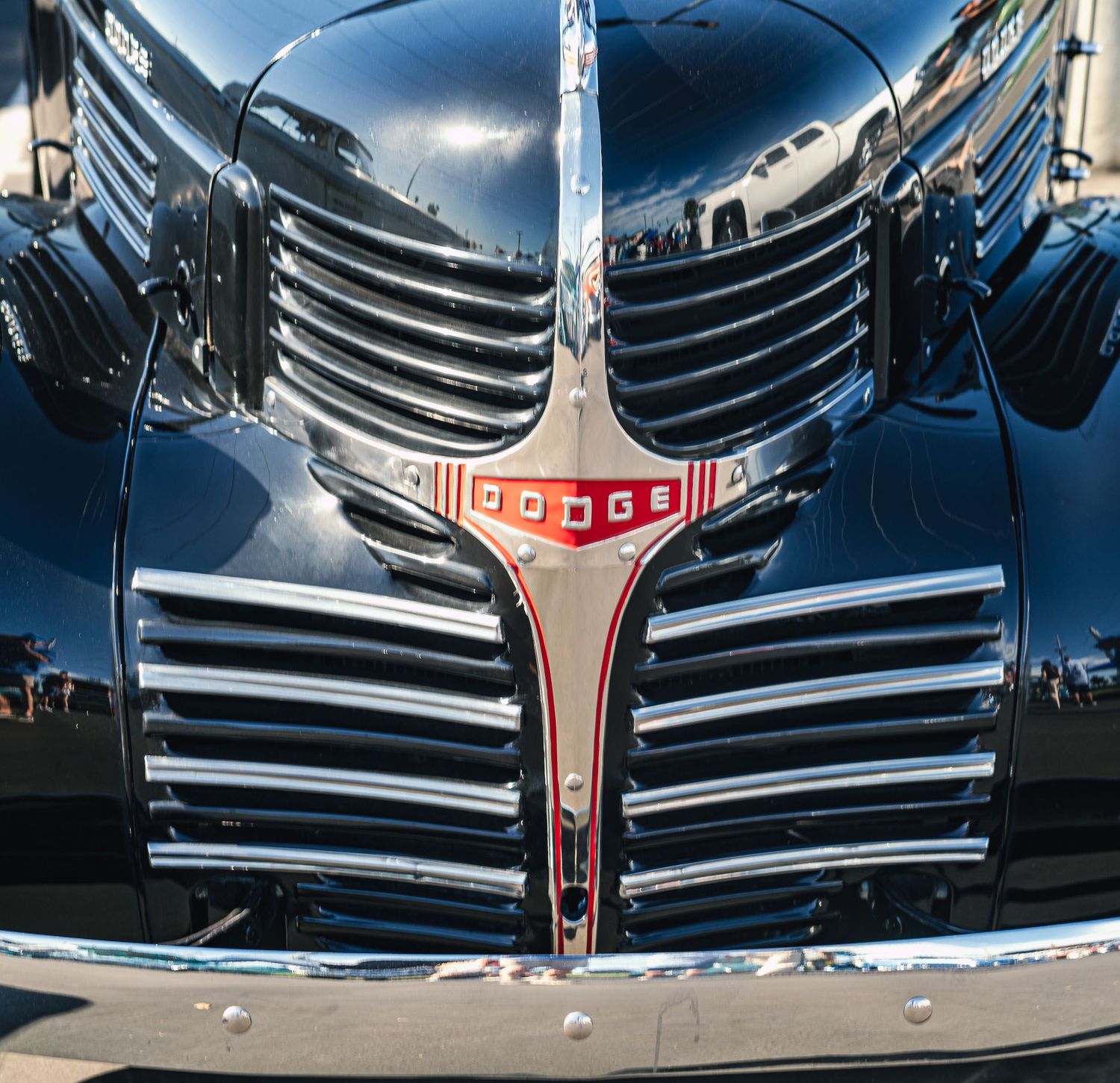 Close-up of a classic Dodge car's chrome grille and emblem, showcasing vintage automotive design.