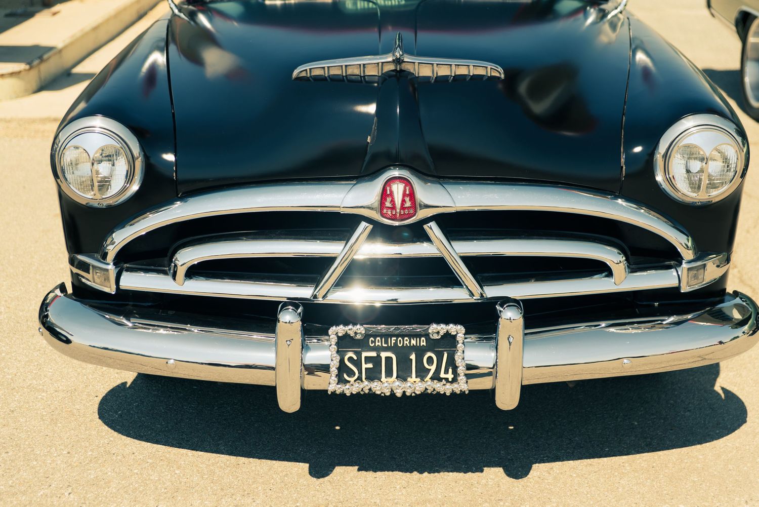 Front view of a classic black Hudson car with chrome grille and California license plate SFD 194.